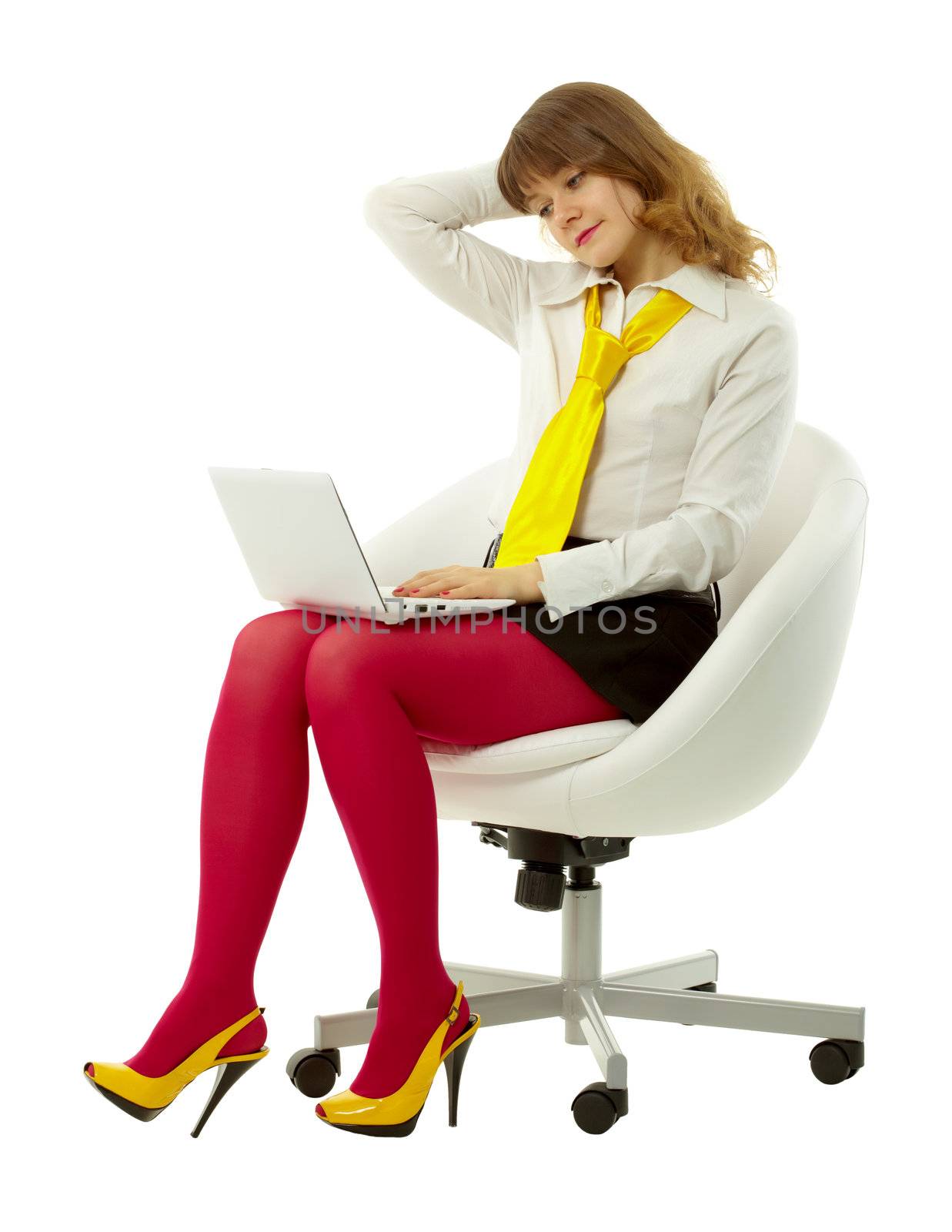 attractive young woman dressed in brightly with a laptop sitting in white chair
