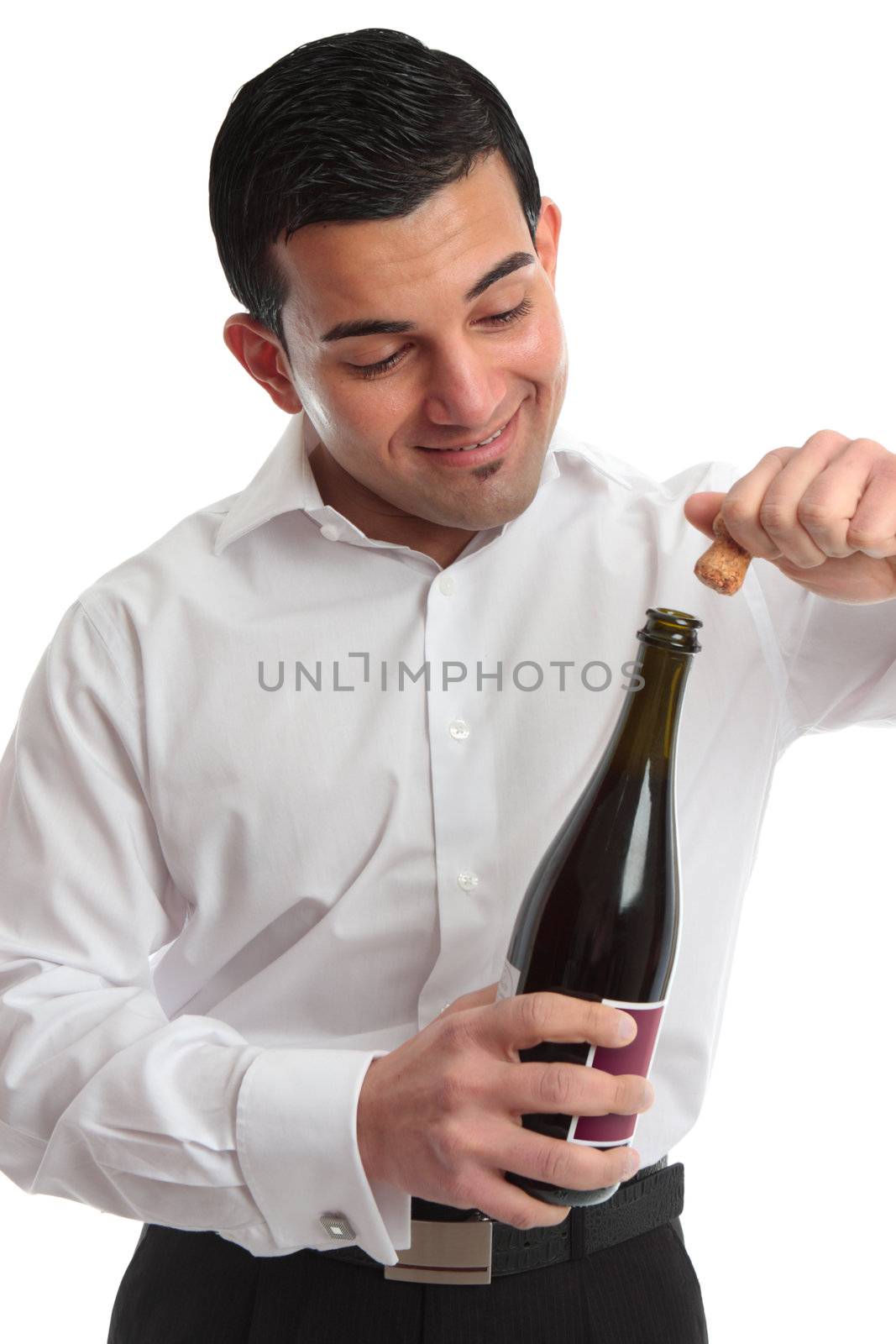 A man or waiter removes a cork from a bottle ready for a celebration.  White background.