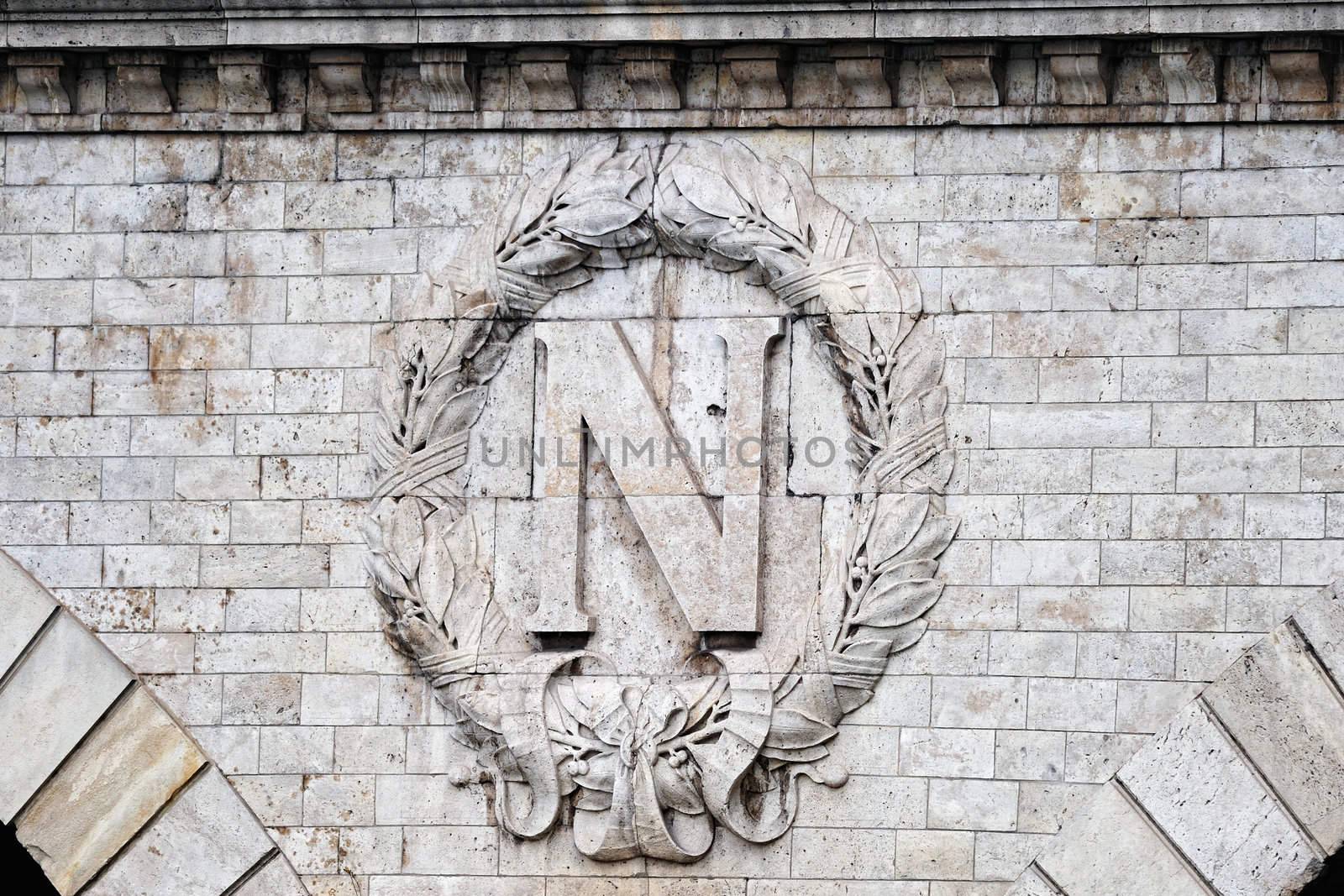 Insignia by Napoleon on the wall of Parisian bridge