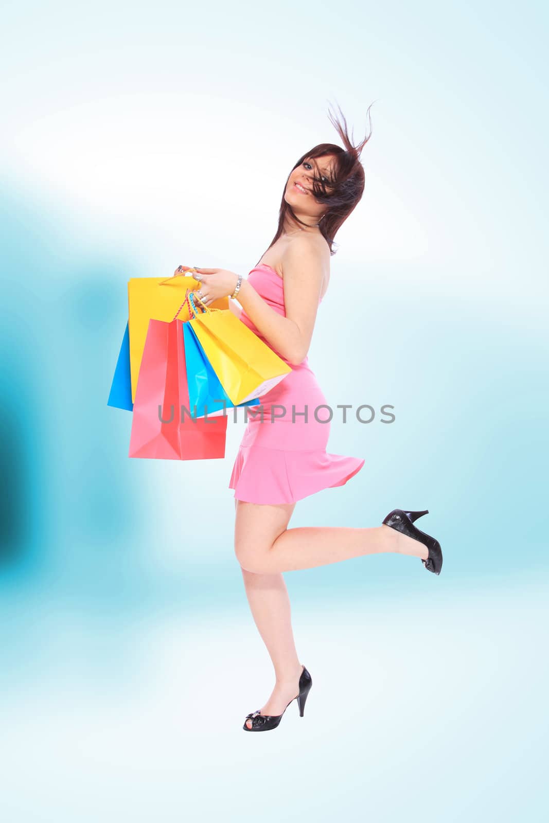 Beautiful, young, woman with colorful shopping bags in her hand 