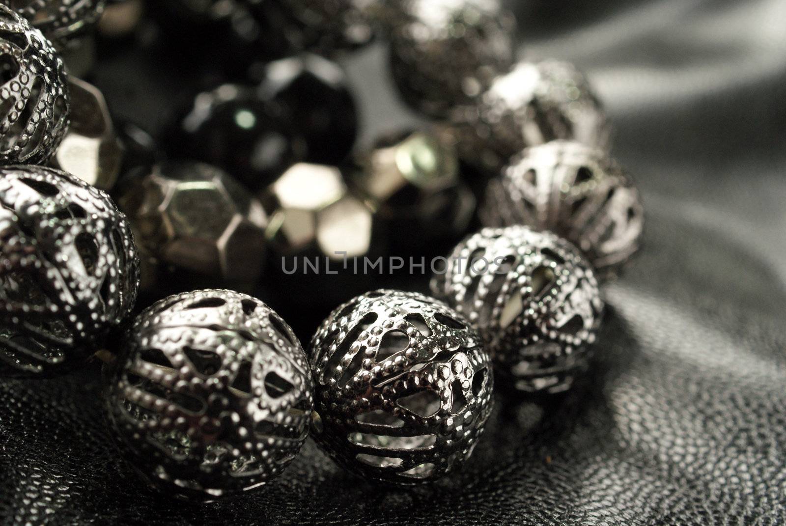 Dark Silver Bead Bracelets over black, shallow depth of field, suitable for backgrounds.