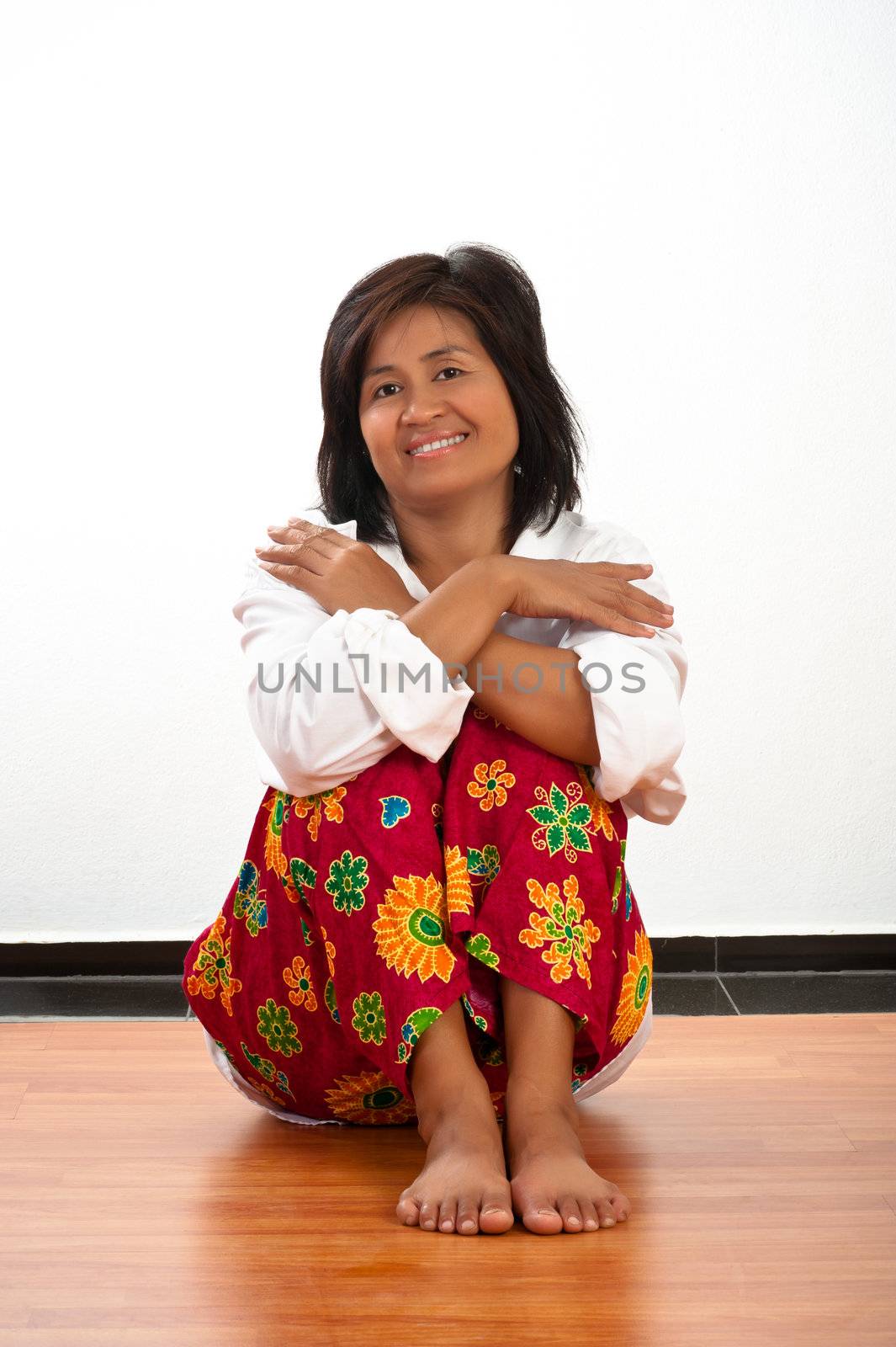 portrait of a happy smiling young Asian woman sitting on the floor