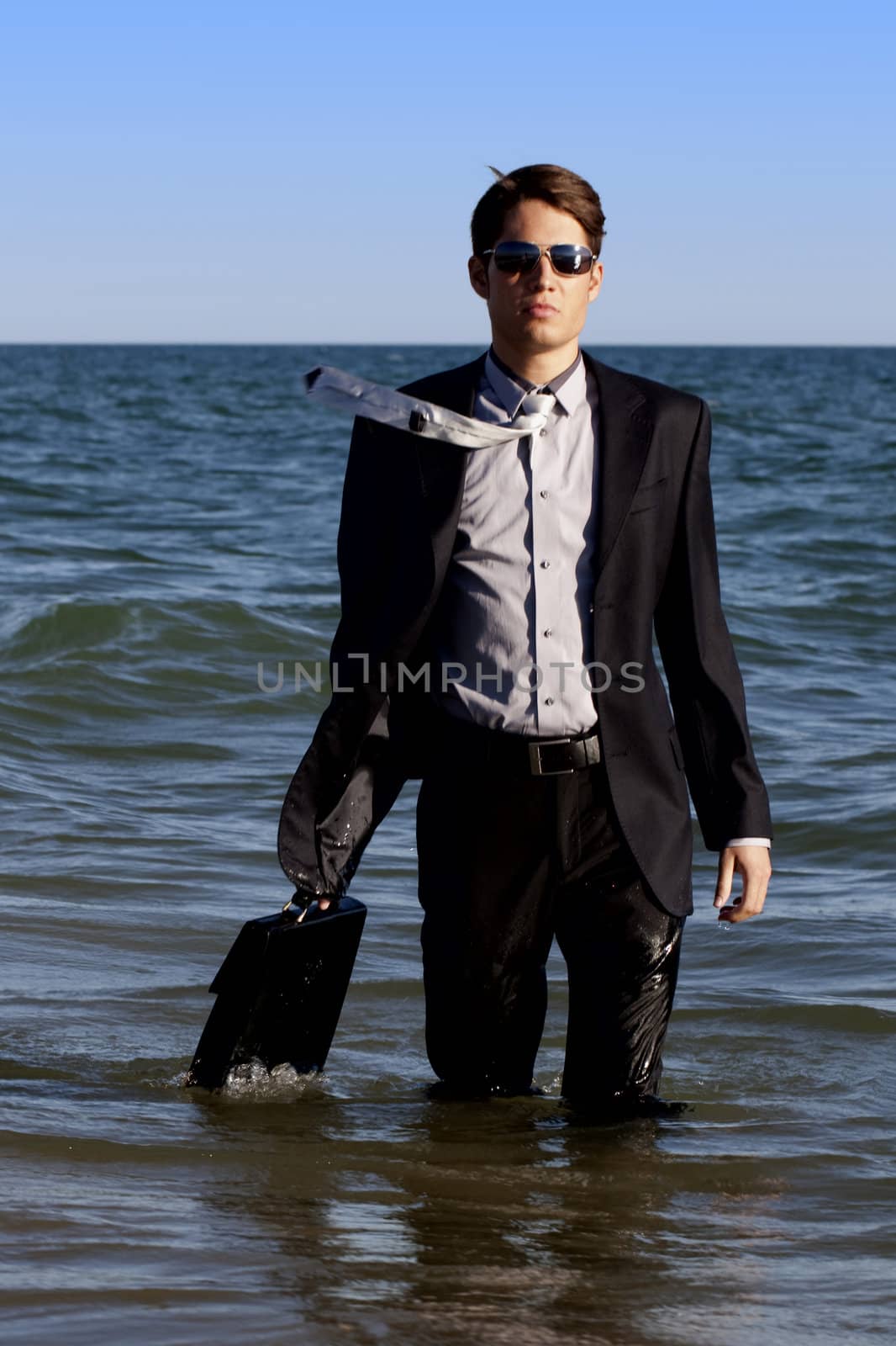 Brave business man in the shoreline of the beach.
