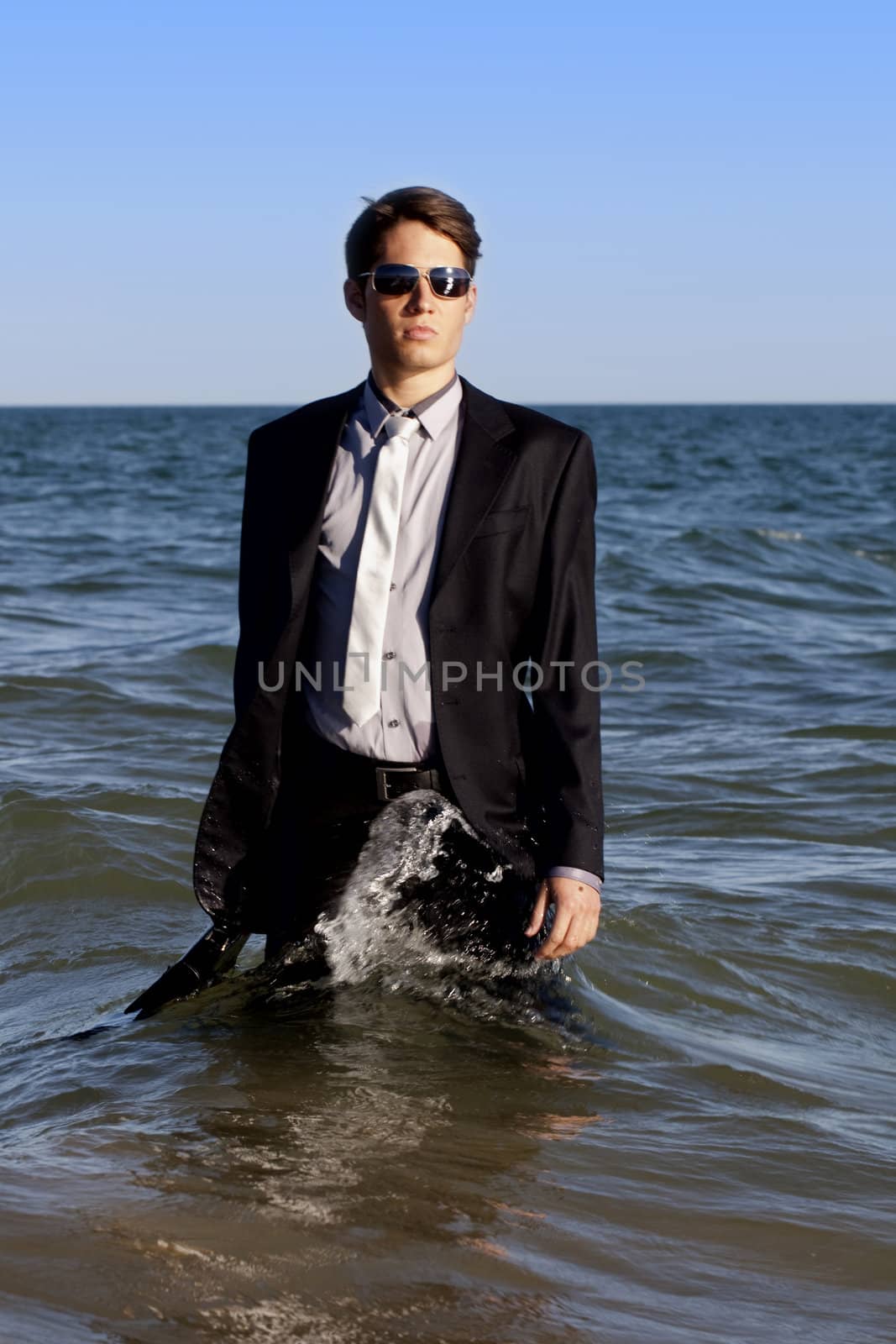 Brave business man in the shoreline of the beach.