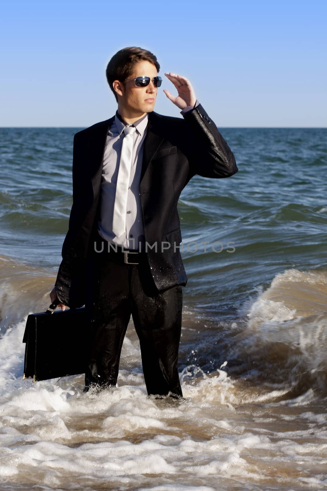 Brave business man in the shoreline of the beach.