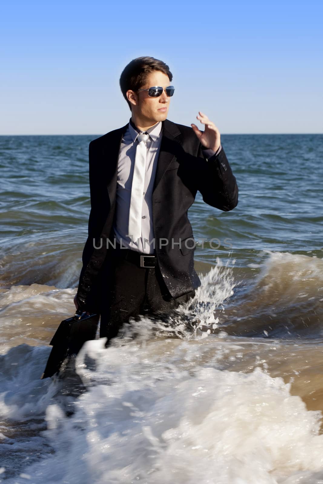 Brave business man in the shoreline of the beach.