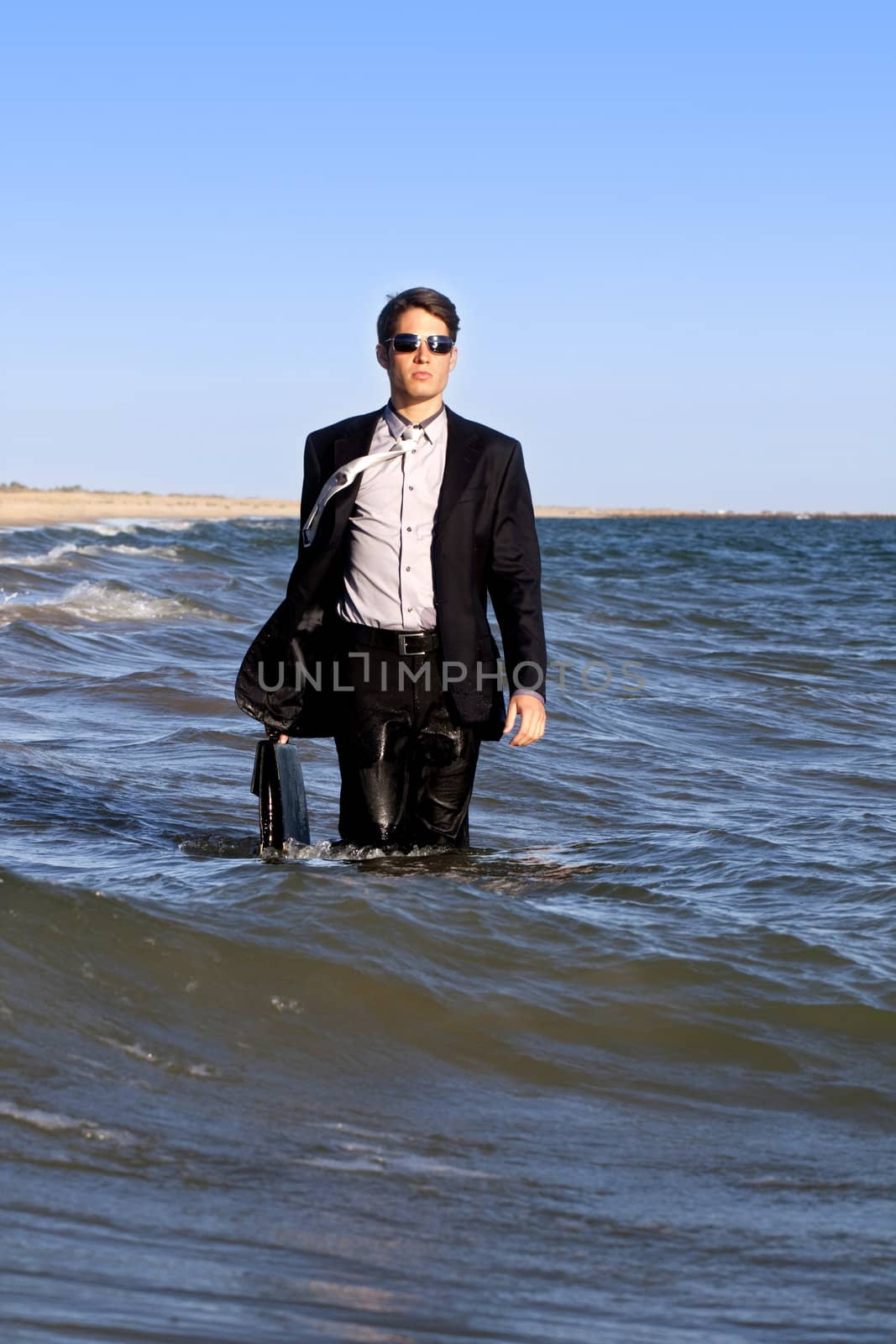 Brave business man in the shoreline of the beach.