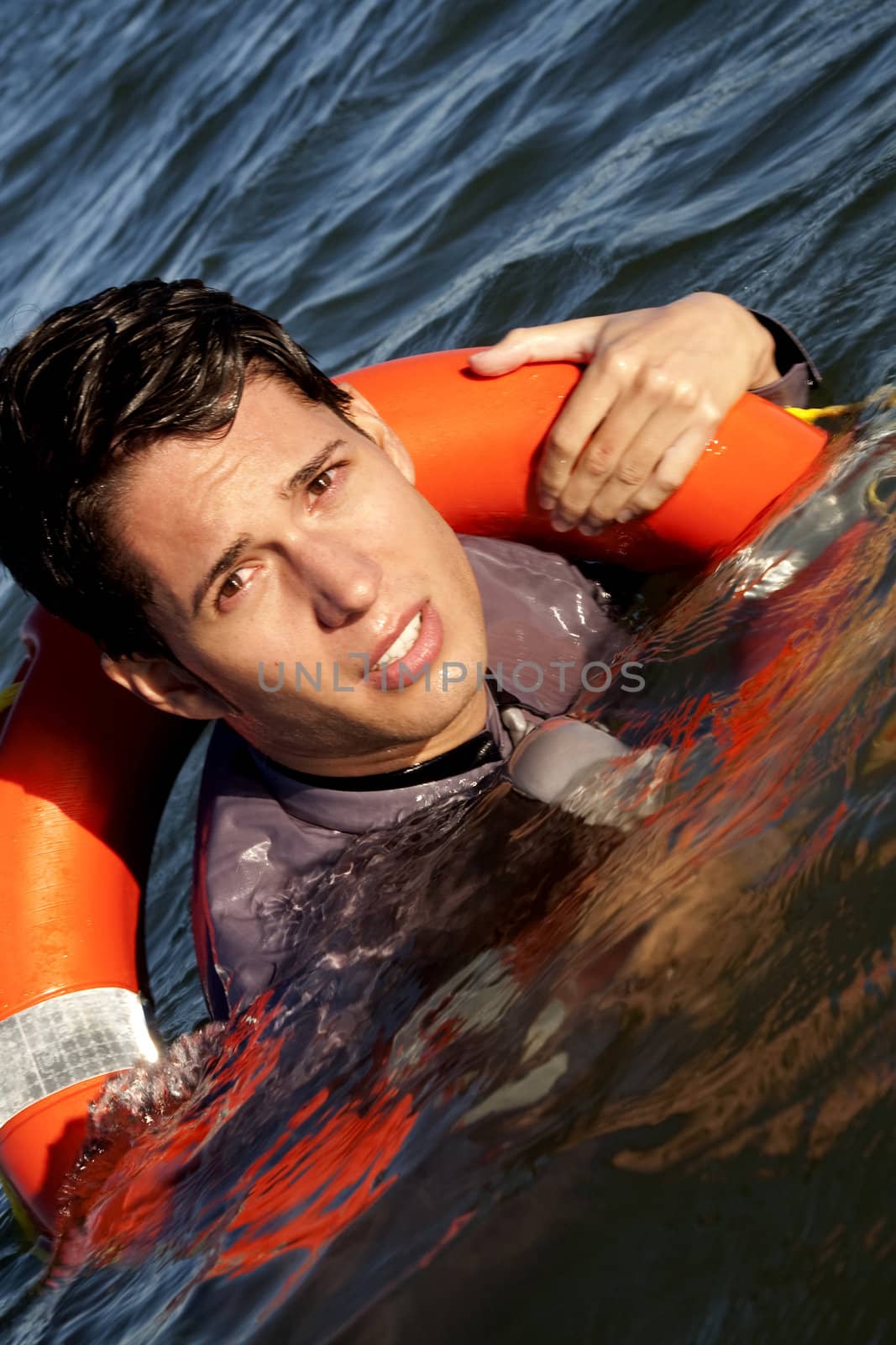 Business man holds a lifesaver buoy on the water.