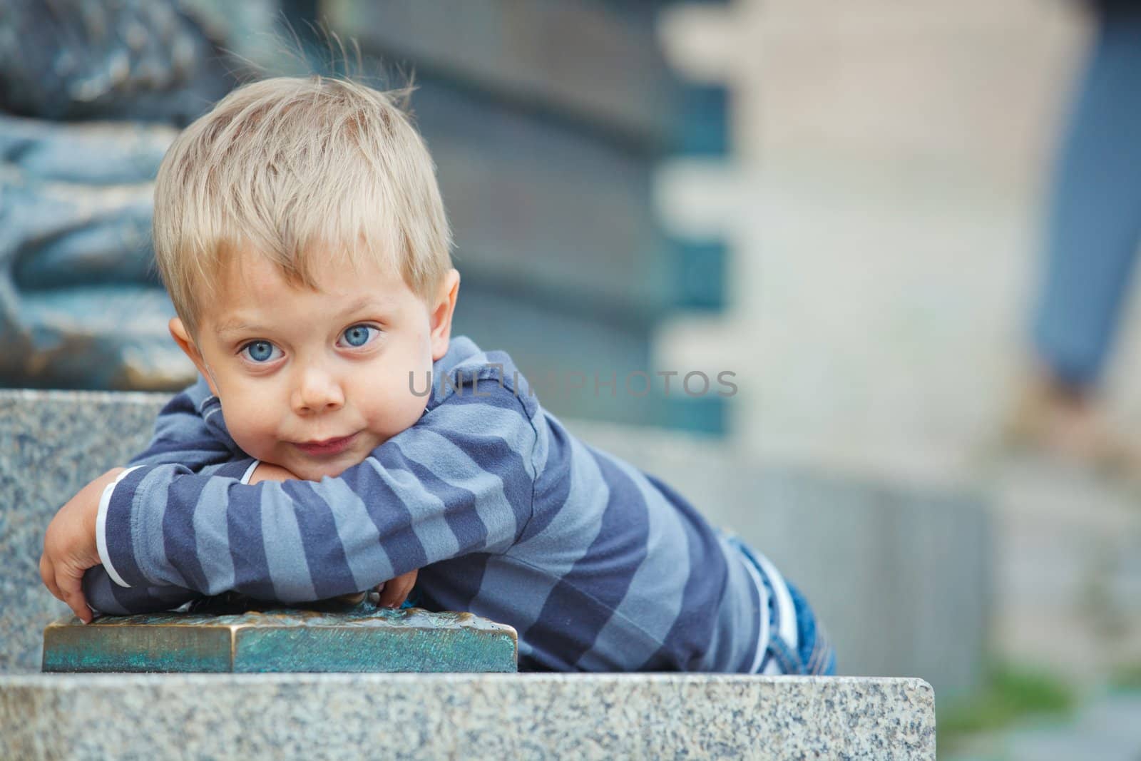 Smiling three year old cute boy clouse-up portrait on town background