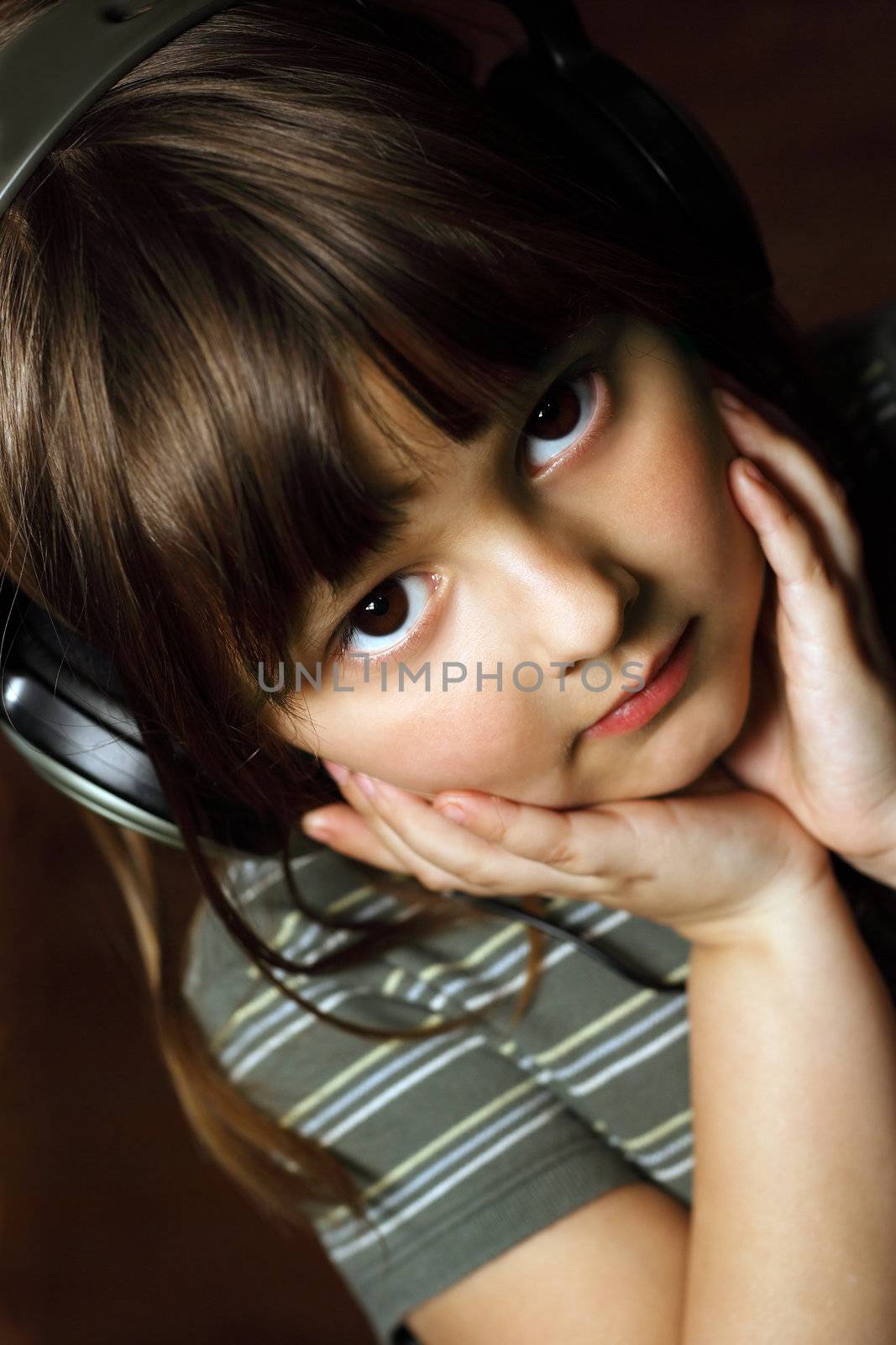 Adorable five year old wearing headphones.
