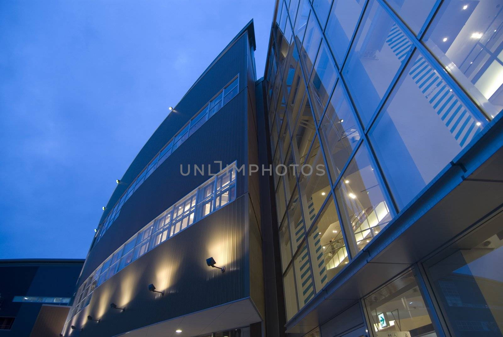 modern exterior  abstract architectural background with wall and window illumination and blue sky