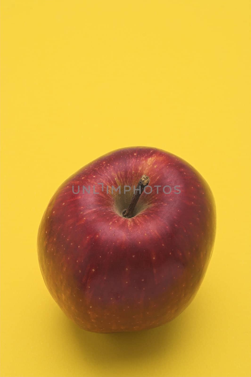 red apple over yellow background
