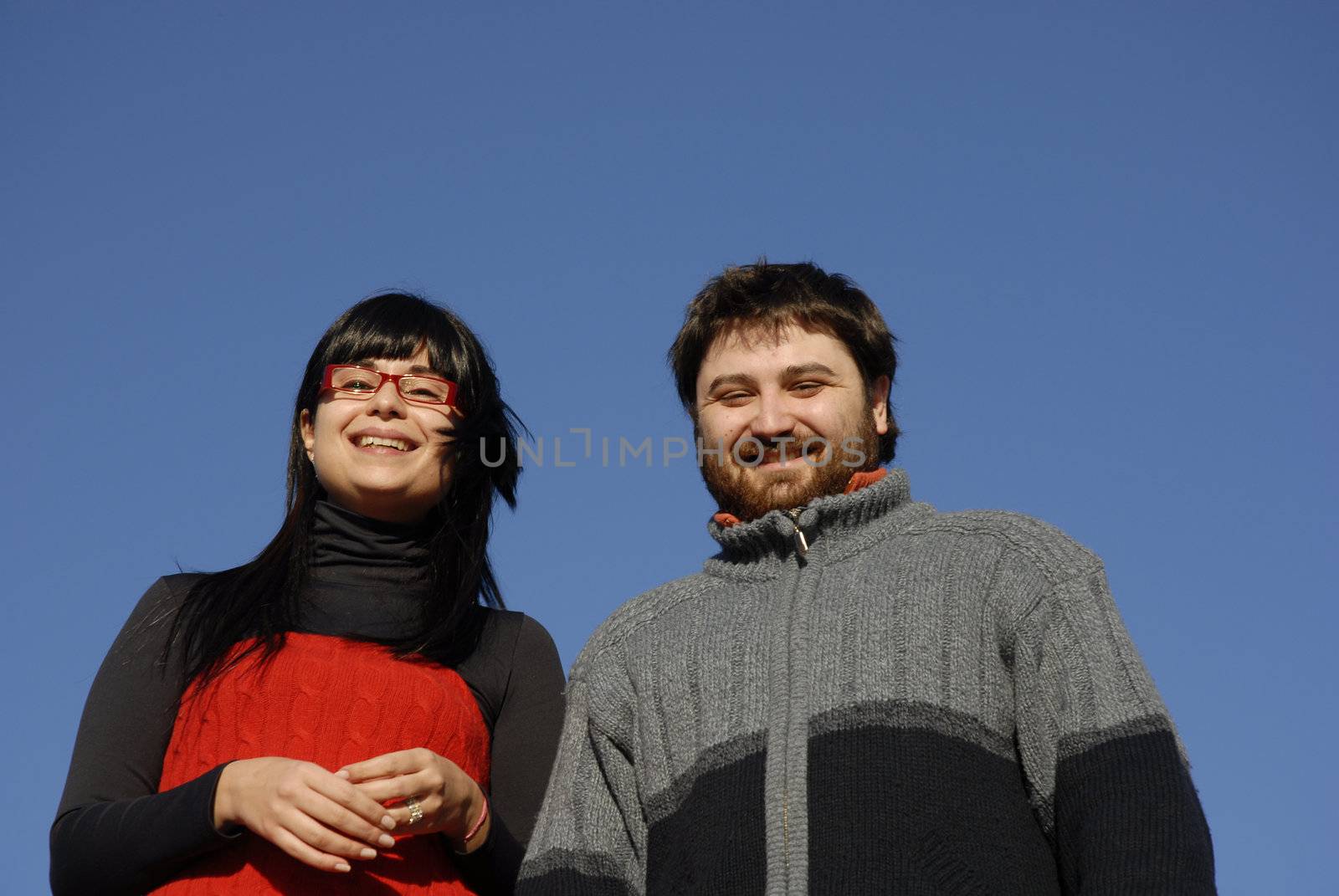 young couple with the sky as background
