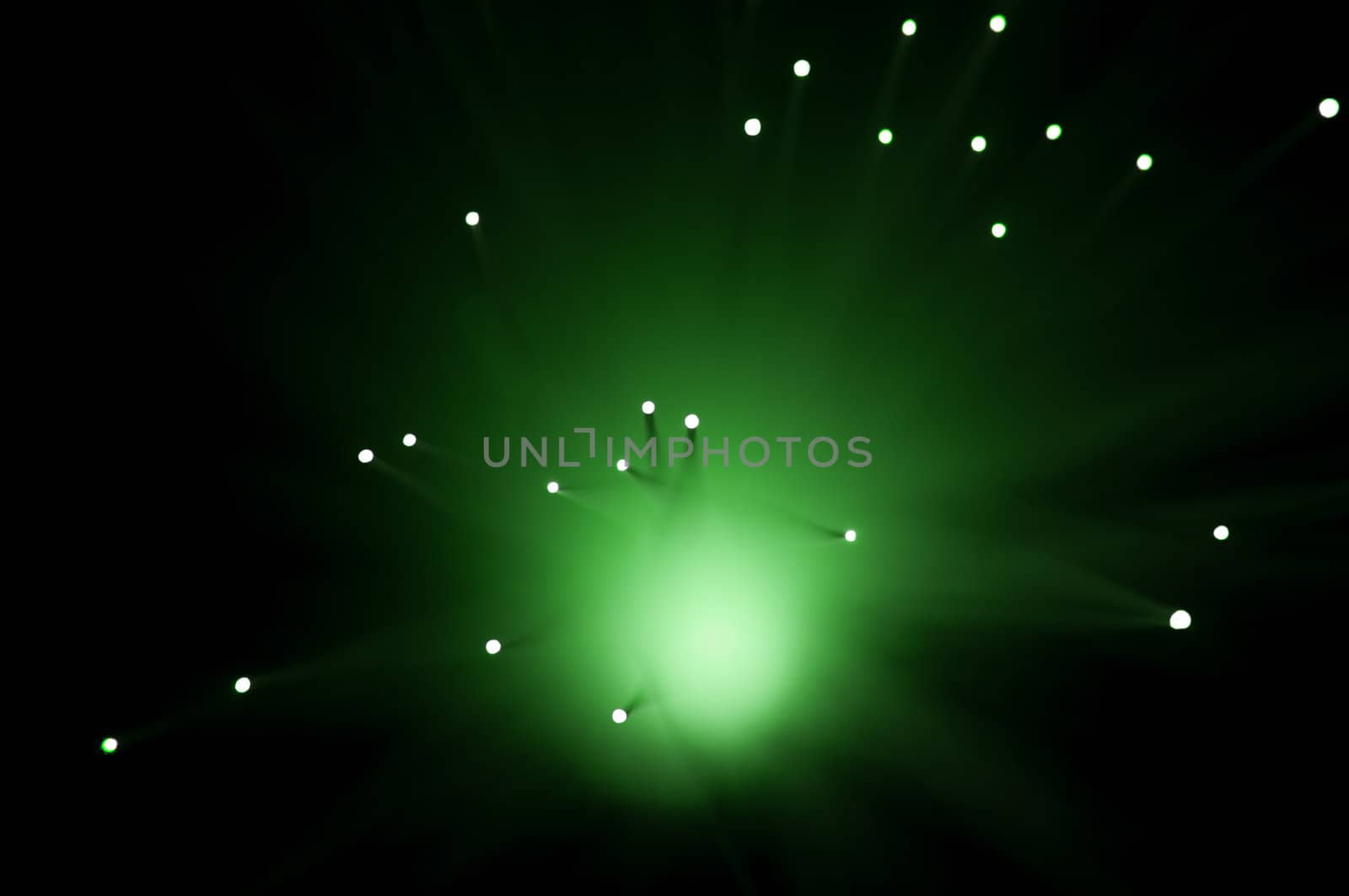 Abstract style capturing the ends of green illuminated fibre optic strands against black.