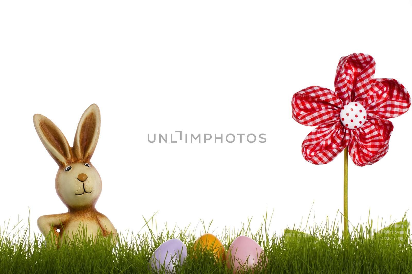 easter bunny behind grass with drapery flower and easter eggs on white background