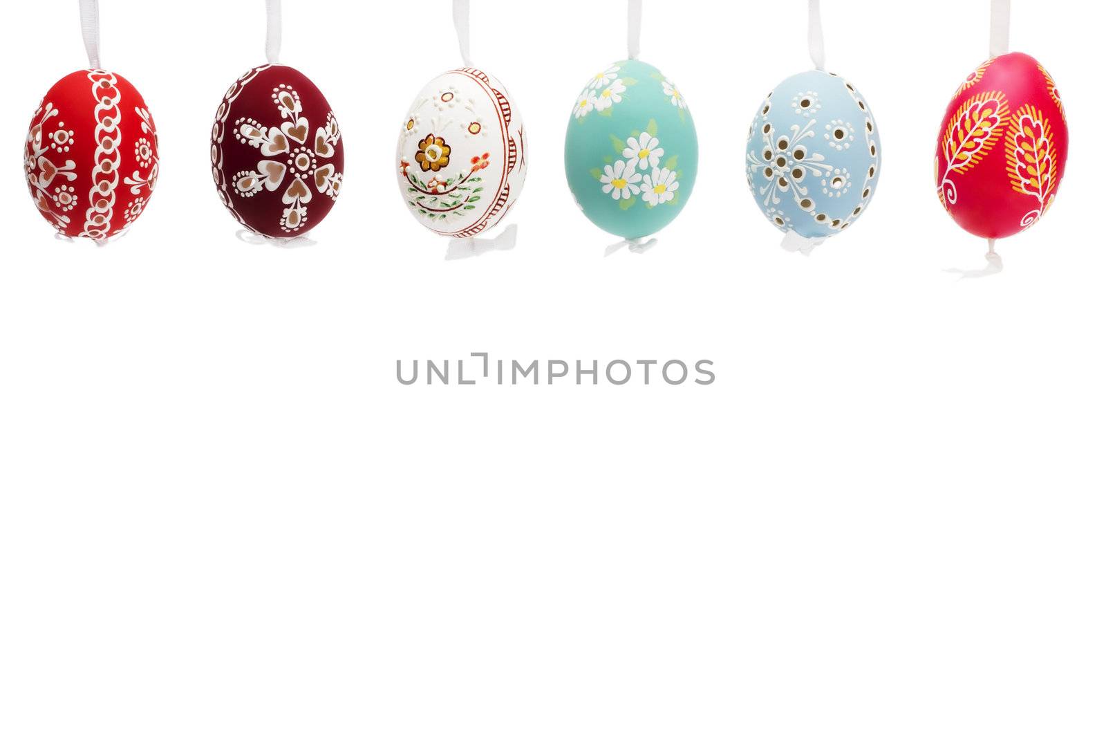 hanging row of hand painted easter eggs on white background