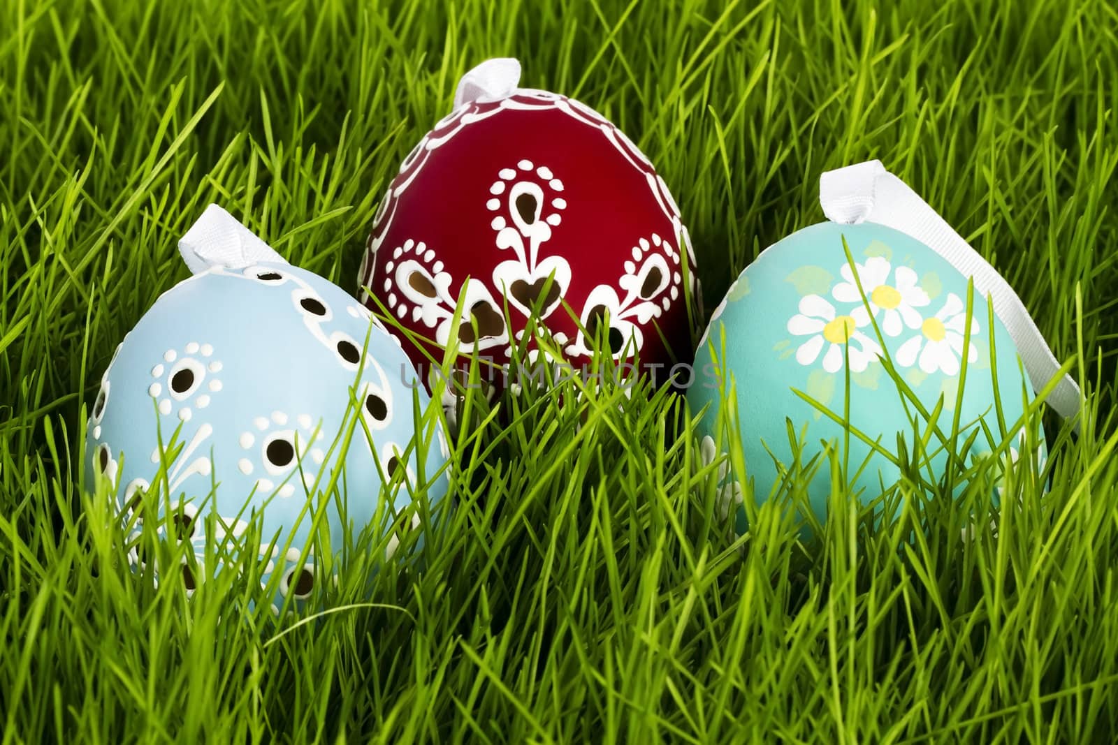 red blue and green hand painted easter eggs in grass