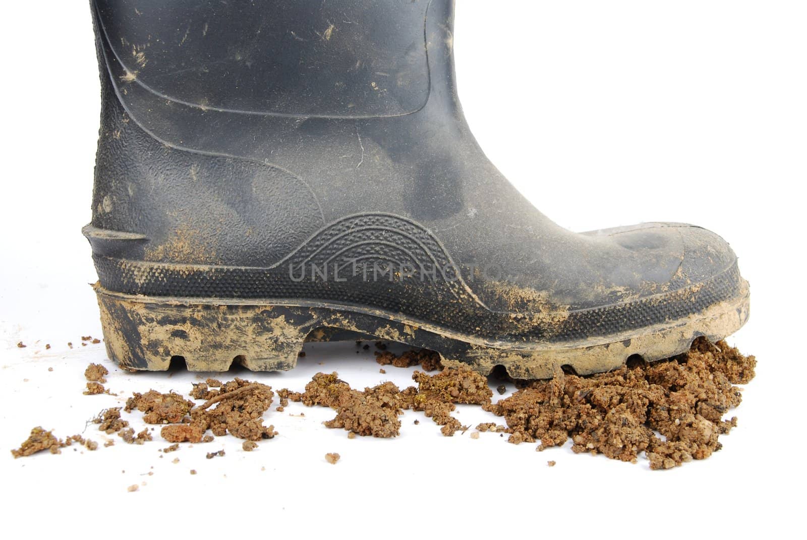 one muddy farmer boot and soil isolated on a white background