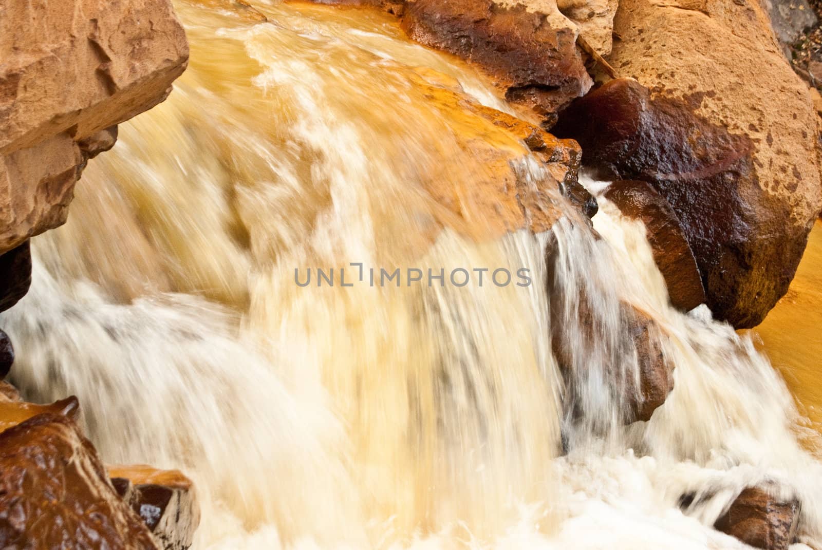 River runs yellow with sediment from gold mining in Colorado mountains near Ouray