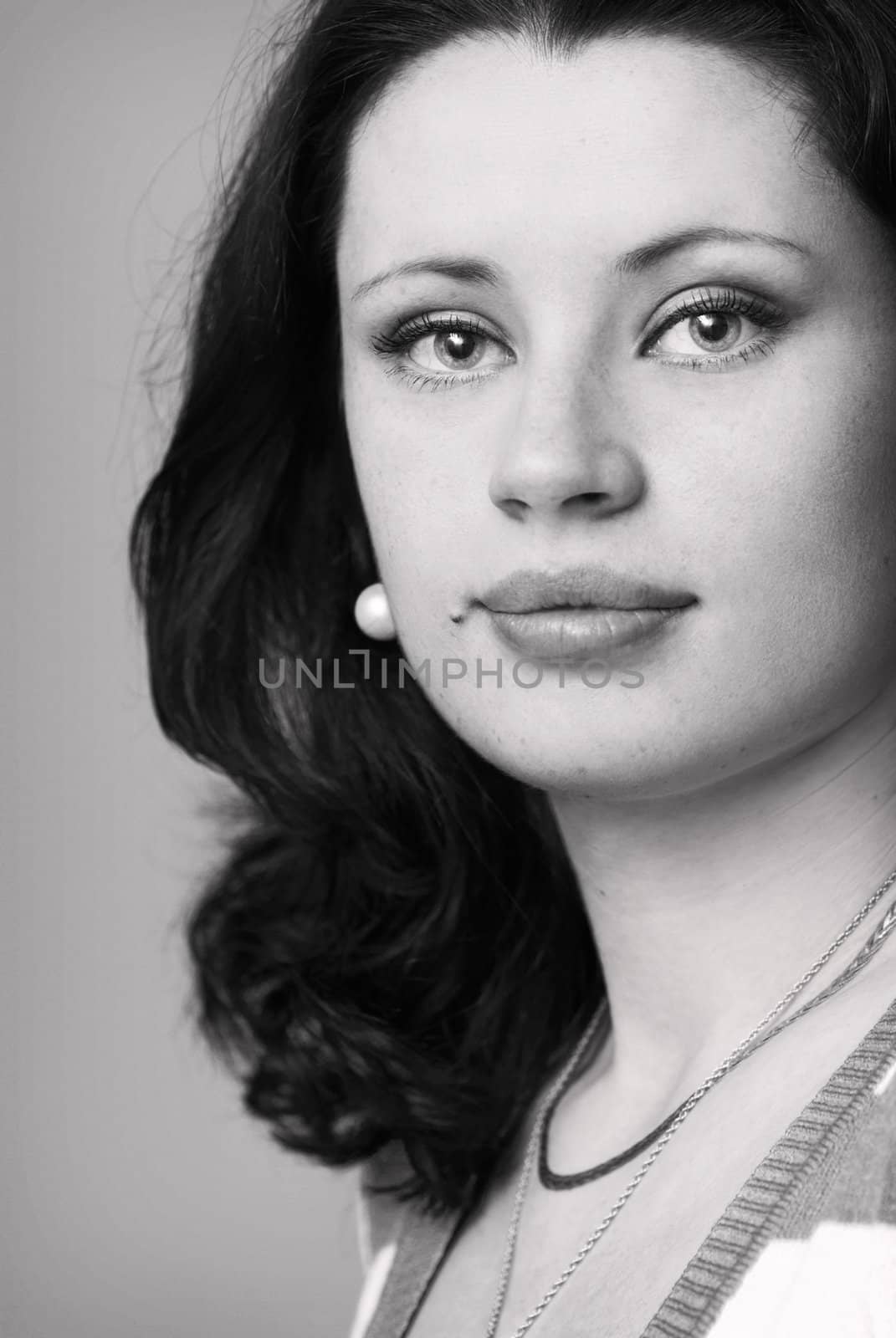 Close-up portrait of attractive young woman with ephelidess in black and white