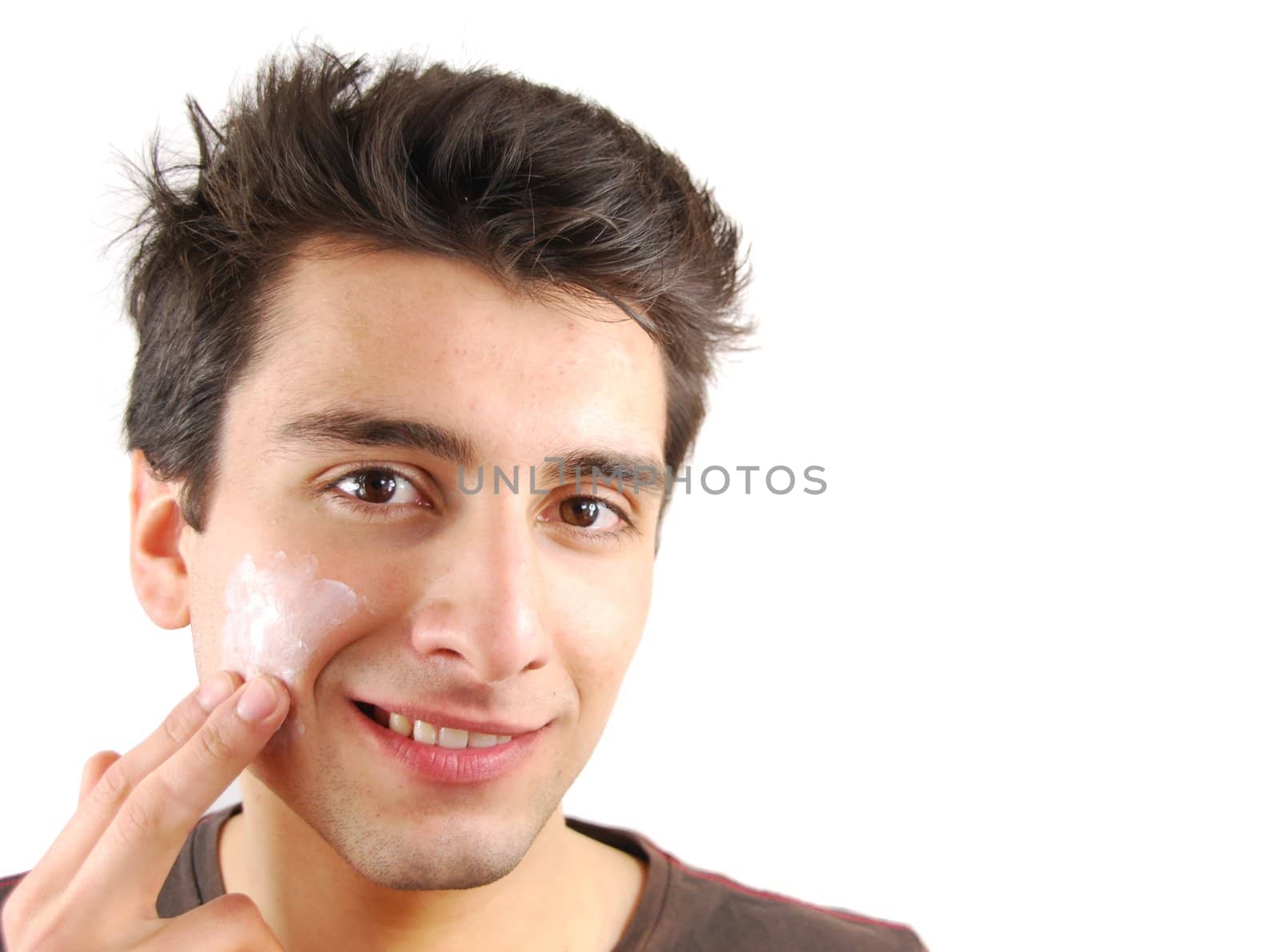 young handsome man applying face cream (over white background)