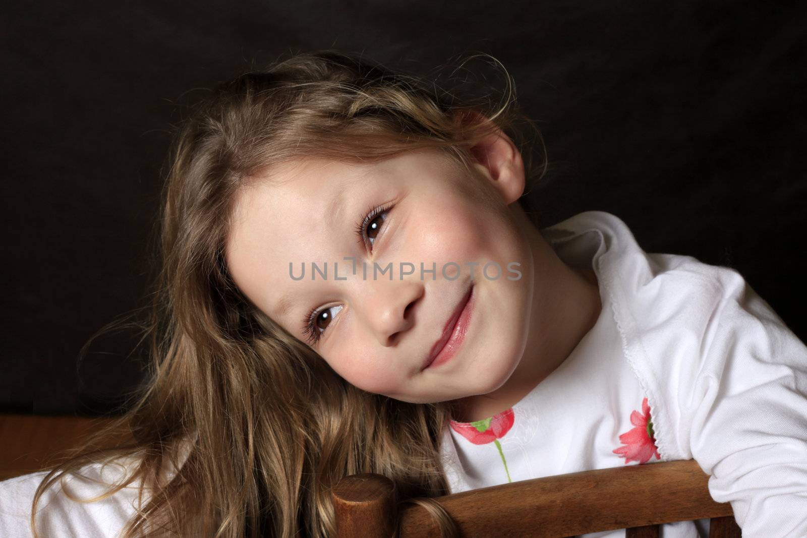 Portrait of young girl smiling on black background