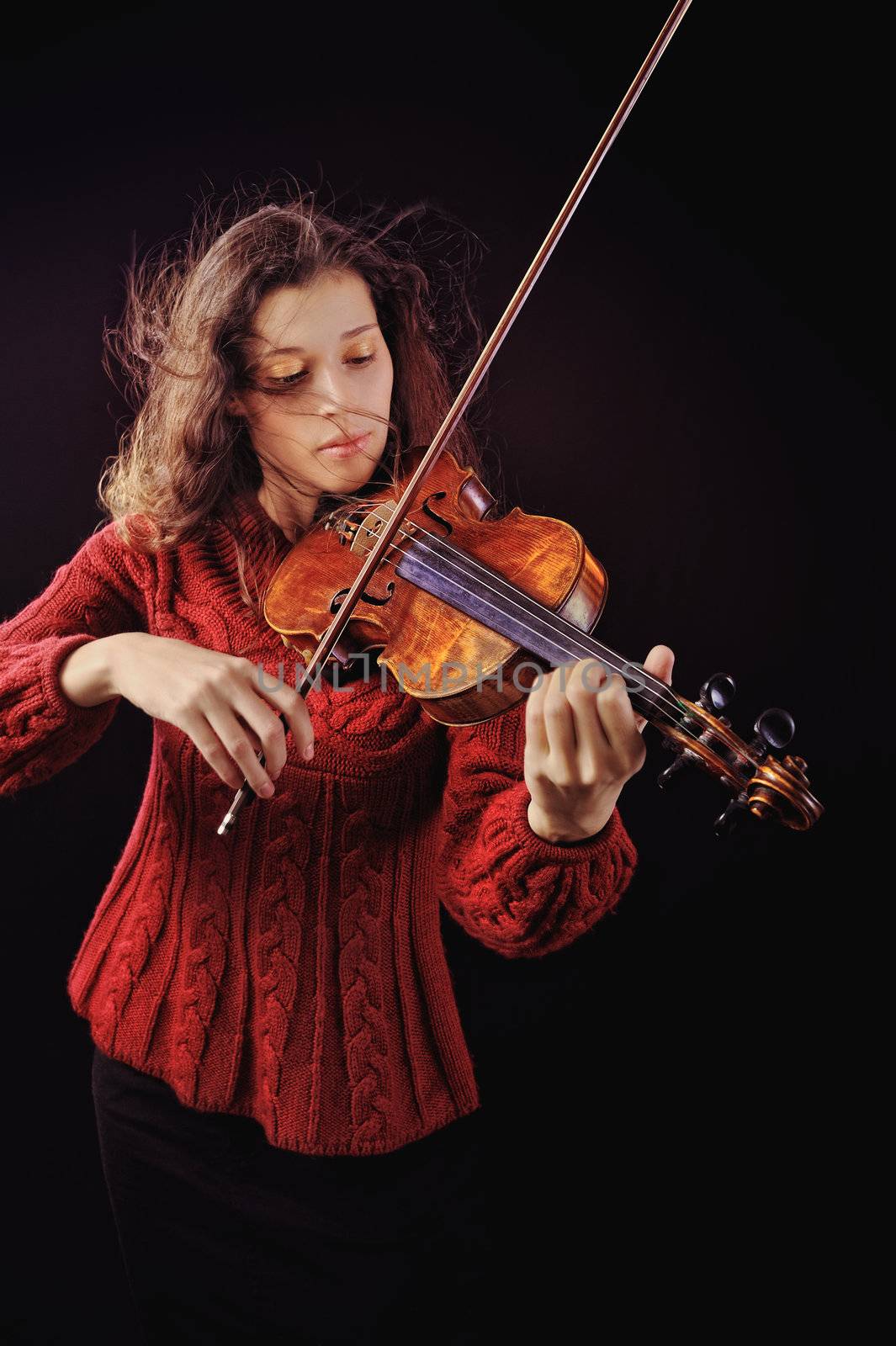 Young woman playing a violin with expression