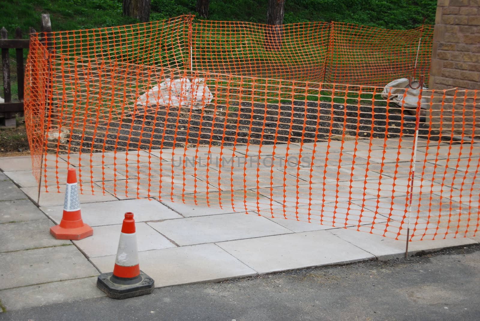 sidewalk construction site with orange cones and delimitation area
