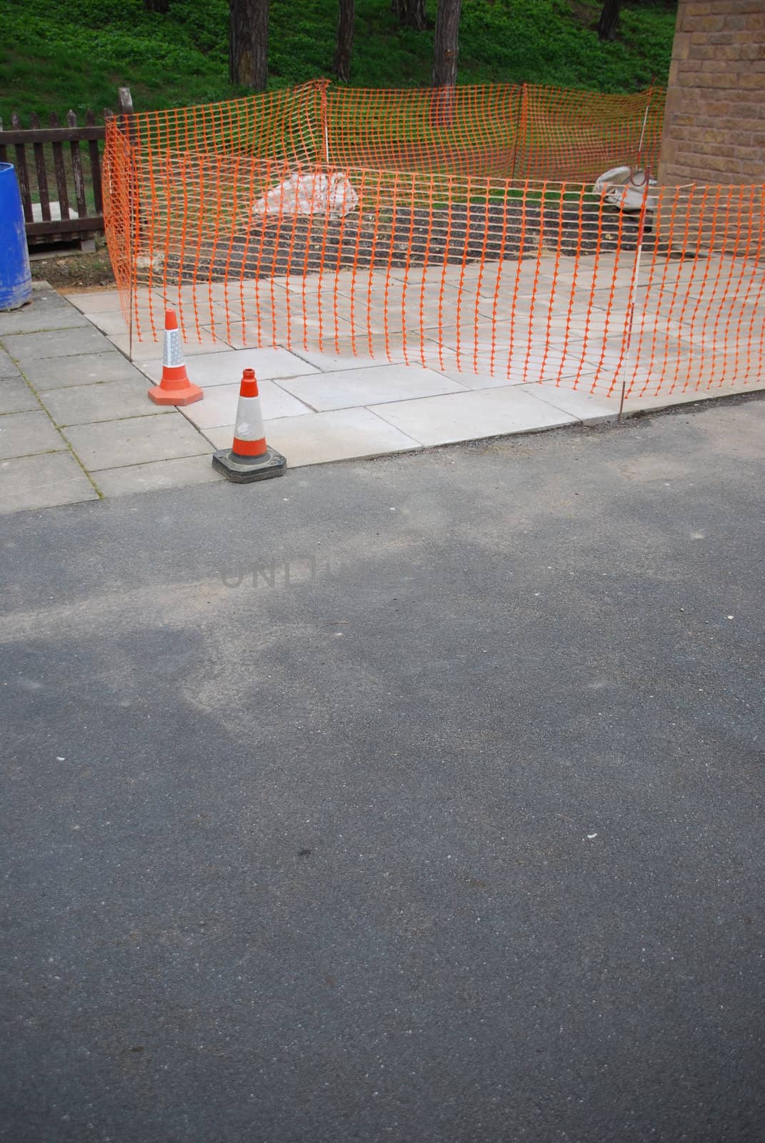 sidewalk construction site with orange cones and delimitation area