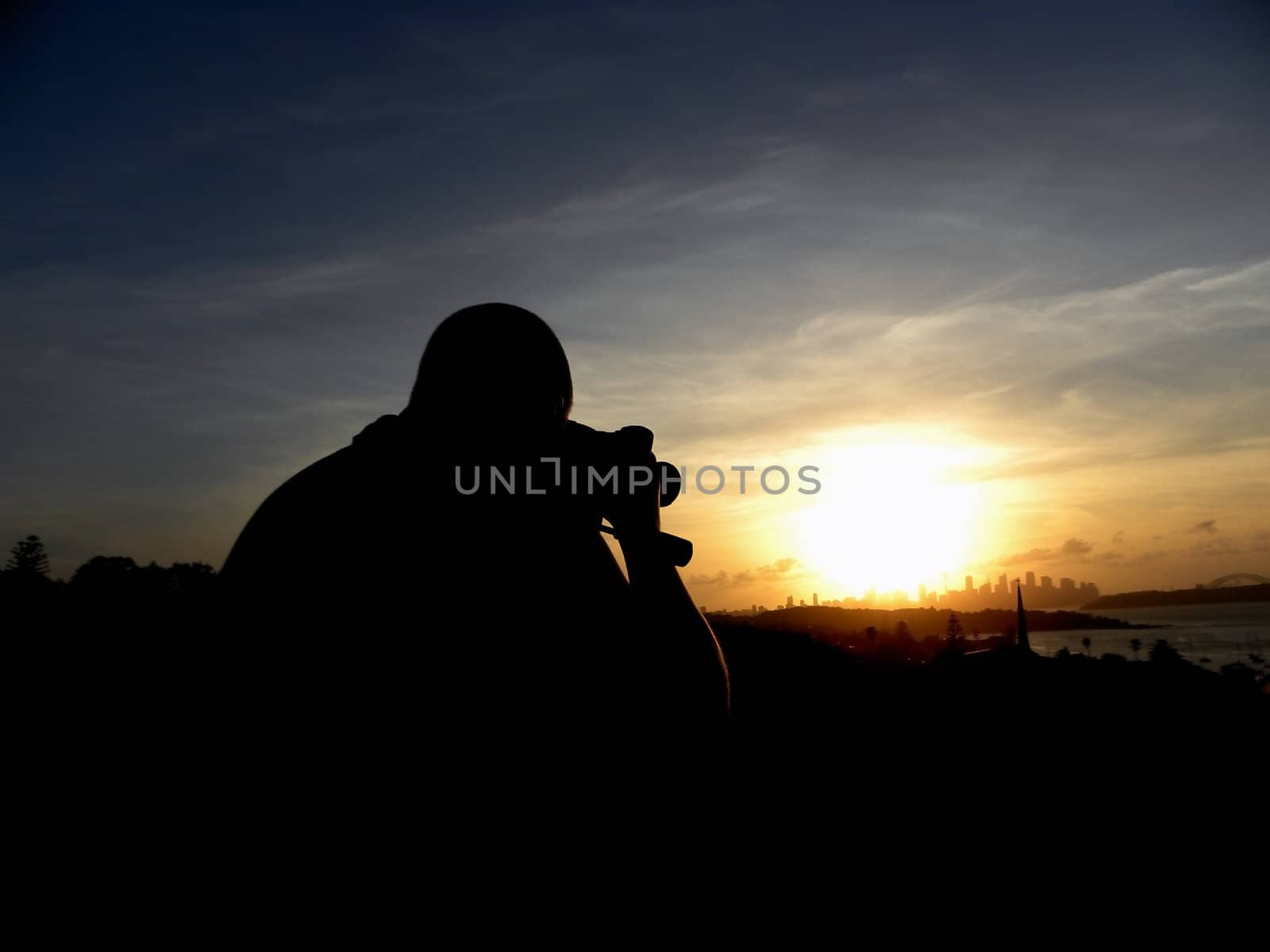 Photo presents a person who takes a picture at sunset background.