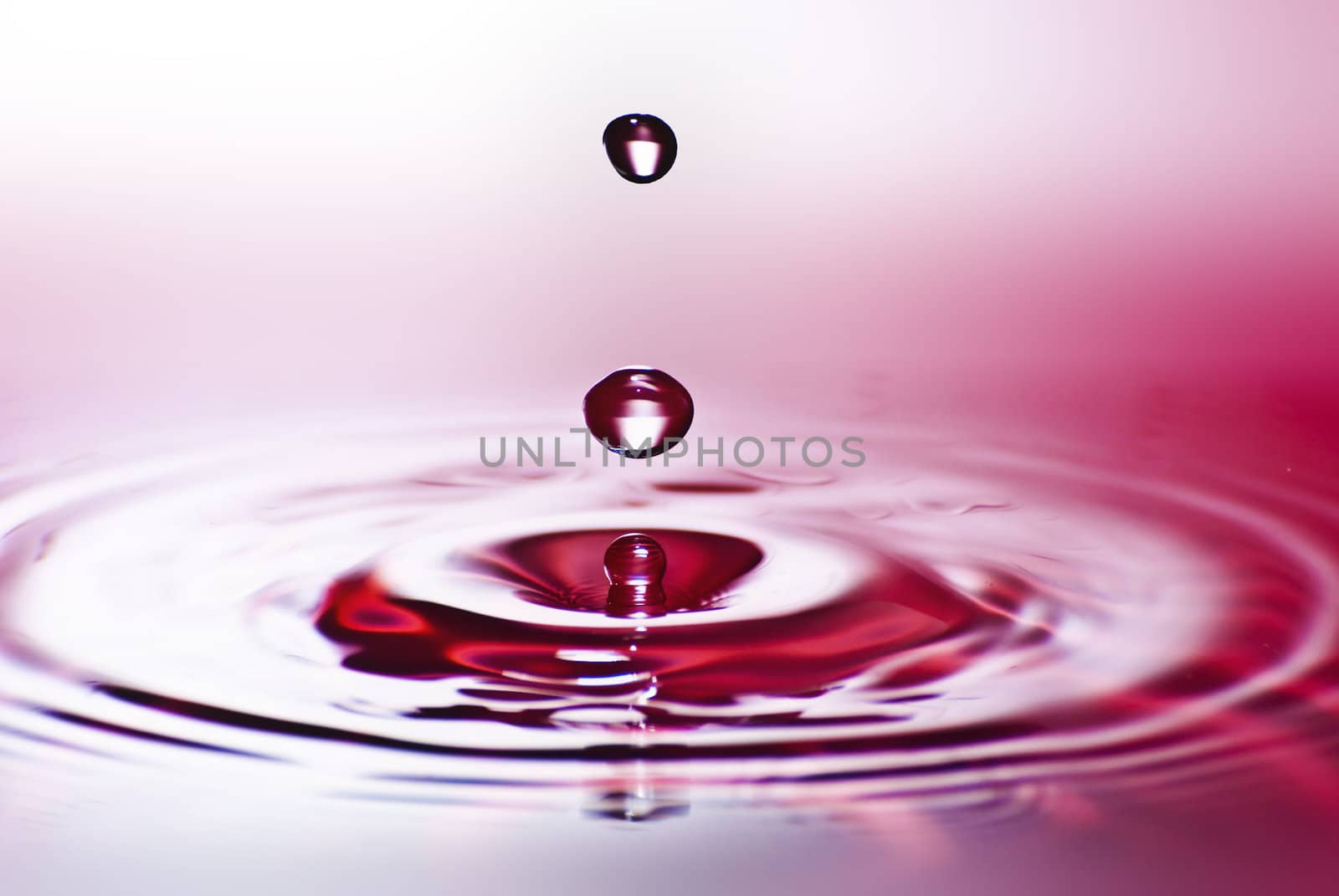 Red water environmental abstract background - red water drop splashing in clear clean water