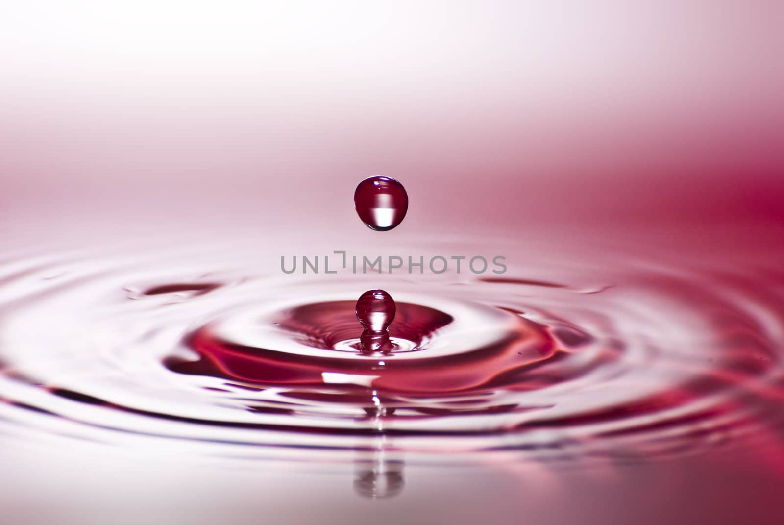 Red water environmental abstract background - red water drop splashing in clear clean water