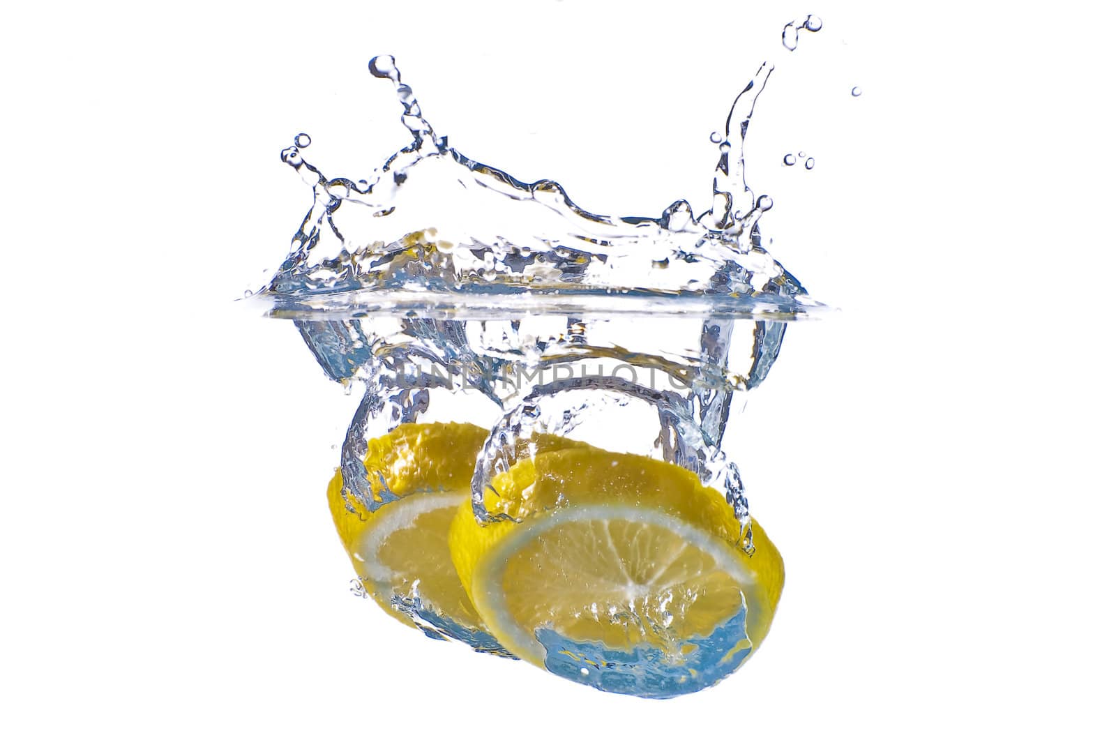 Closeup abstract yellow lemon splashing in clear blue water - isolated against white background.