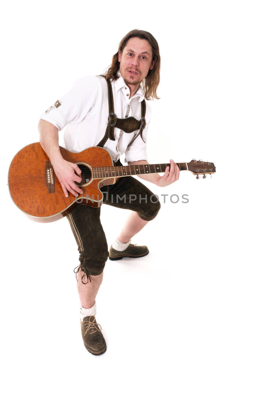 Young bavarian muscian in traditional costume playing guitar