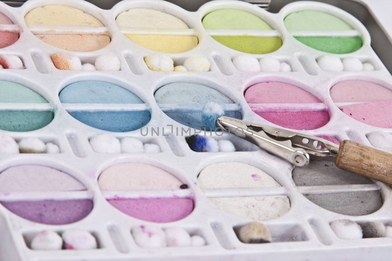 Soft pastel tone chalks in their container with clip tool.