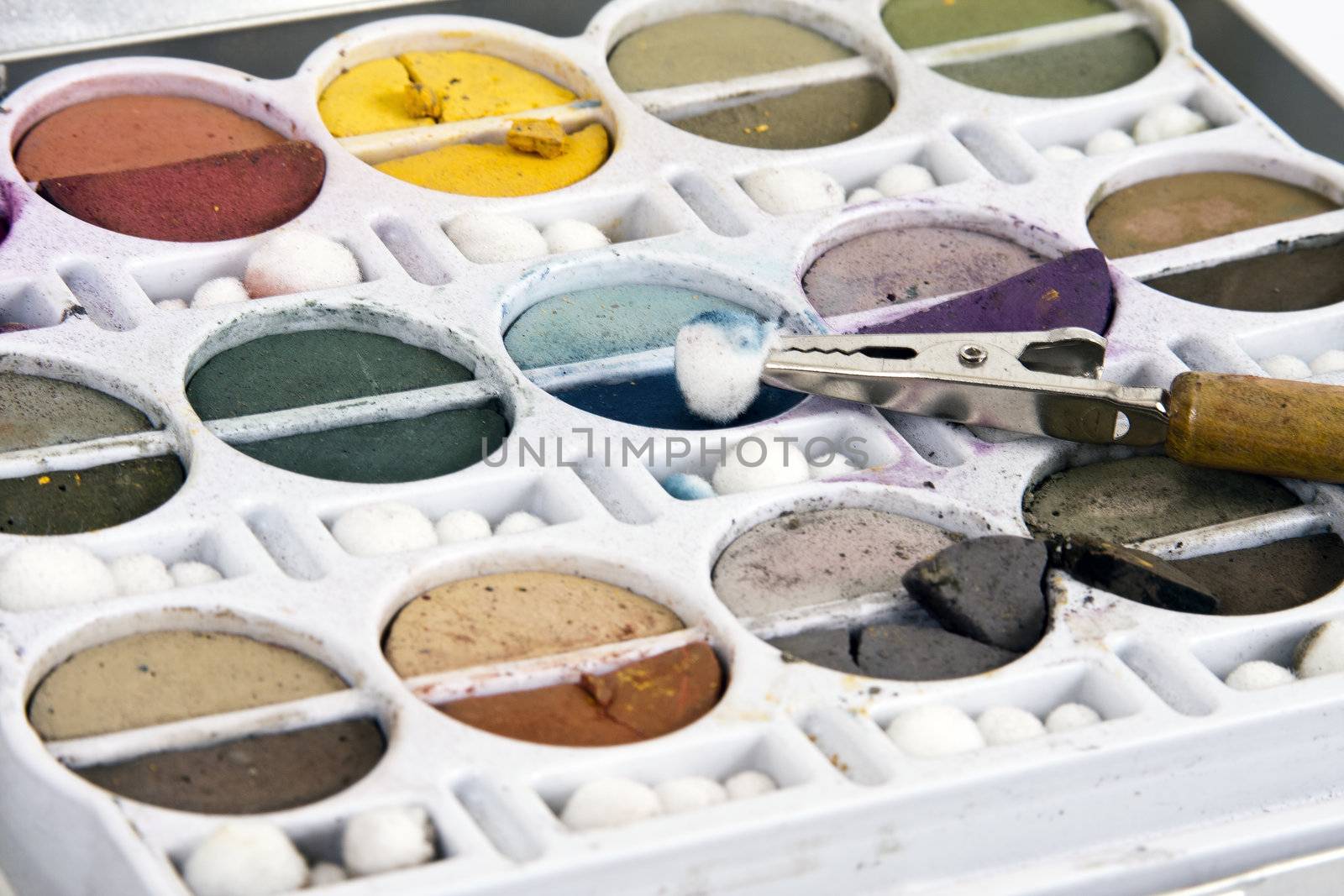 Soft earth tone chalks in their container with clip tool.