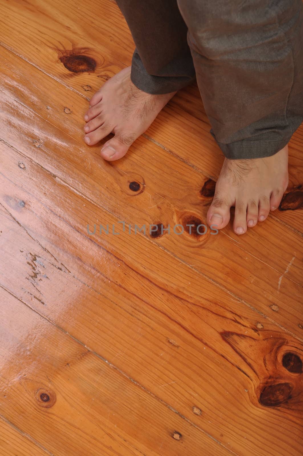 young man bare feet on wooden floor background