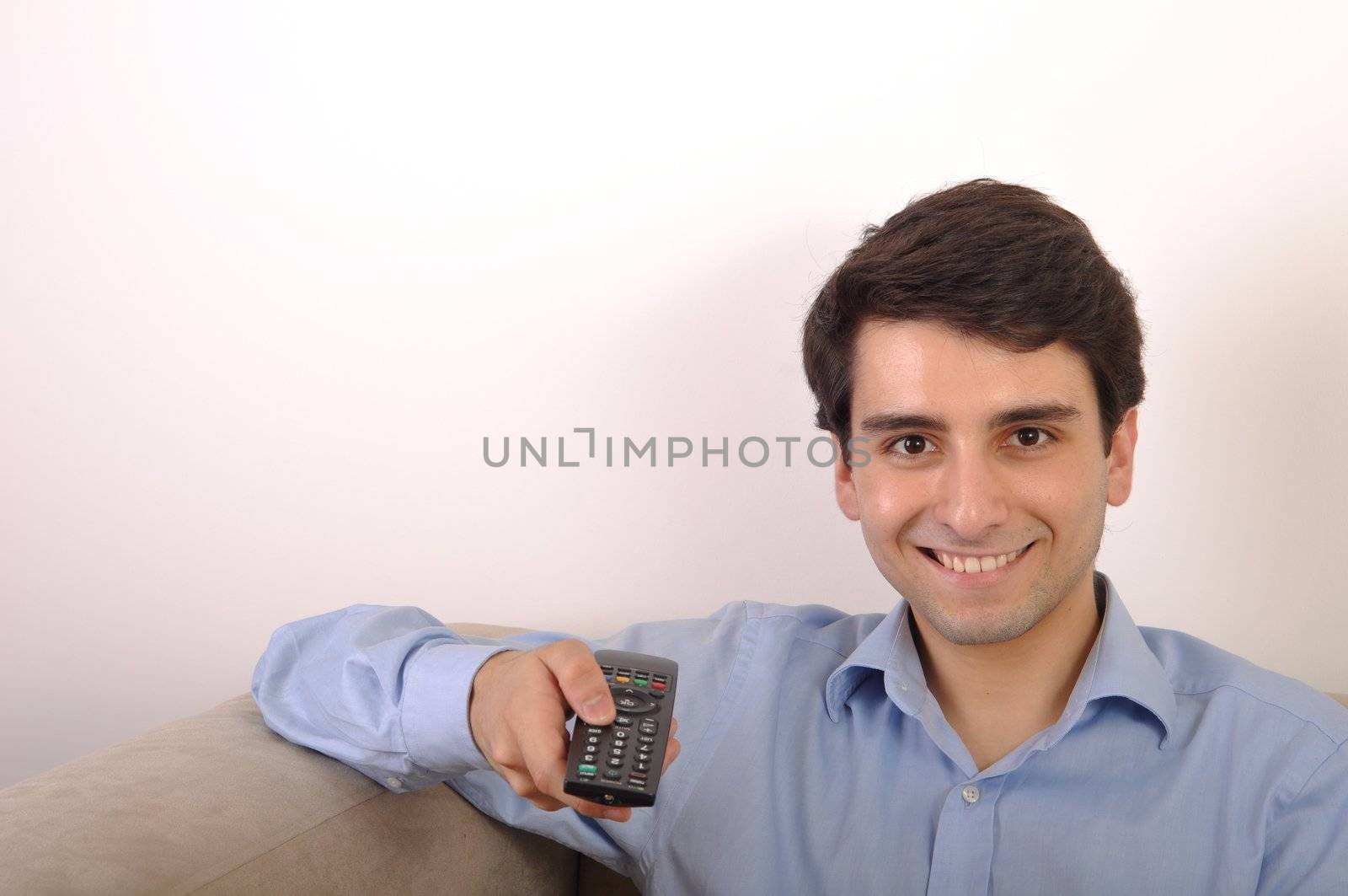 smiling attractive young man watching televison