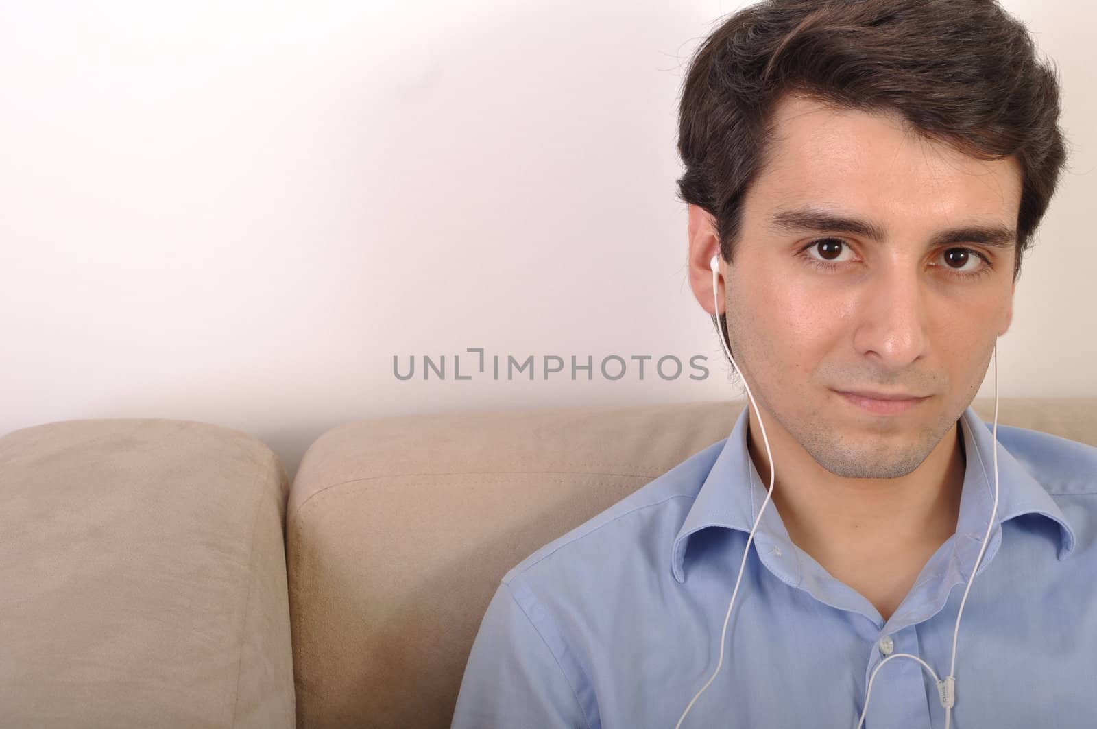 attractive young man listening to music on the couch