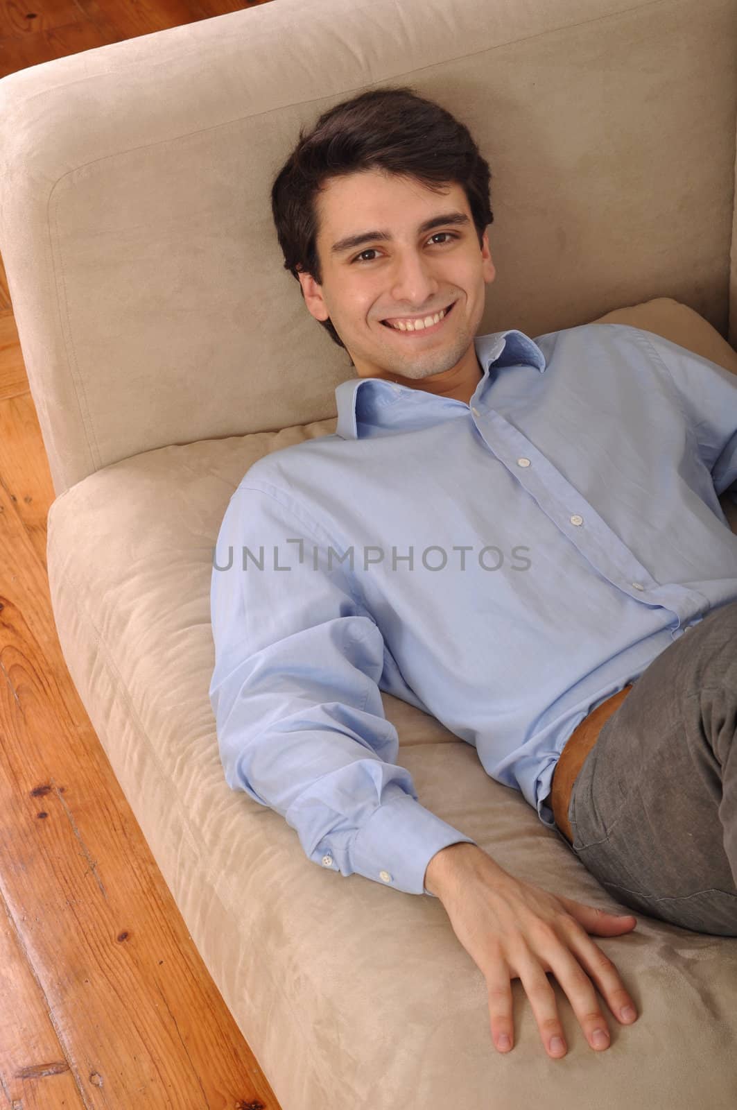 attractive young man lying and relaxing on the couch