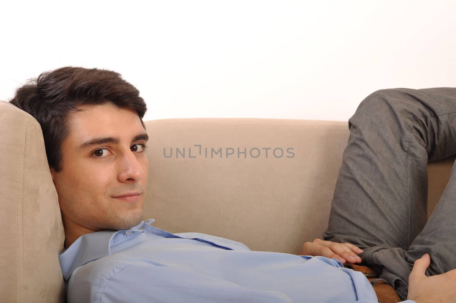 attractive young man lying and relaxing on the couch