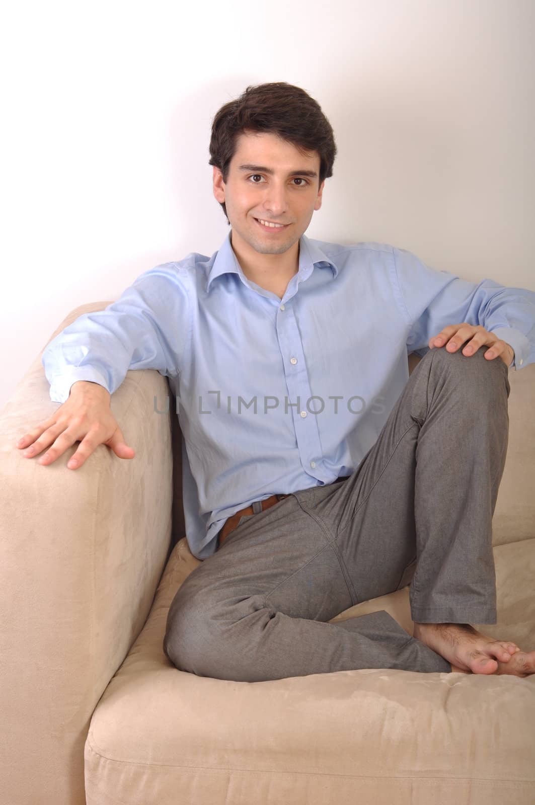 smiling attractive young man sitting on the couch