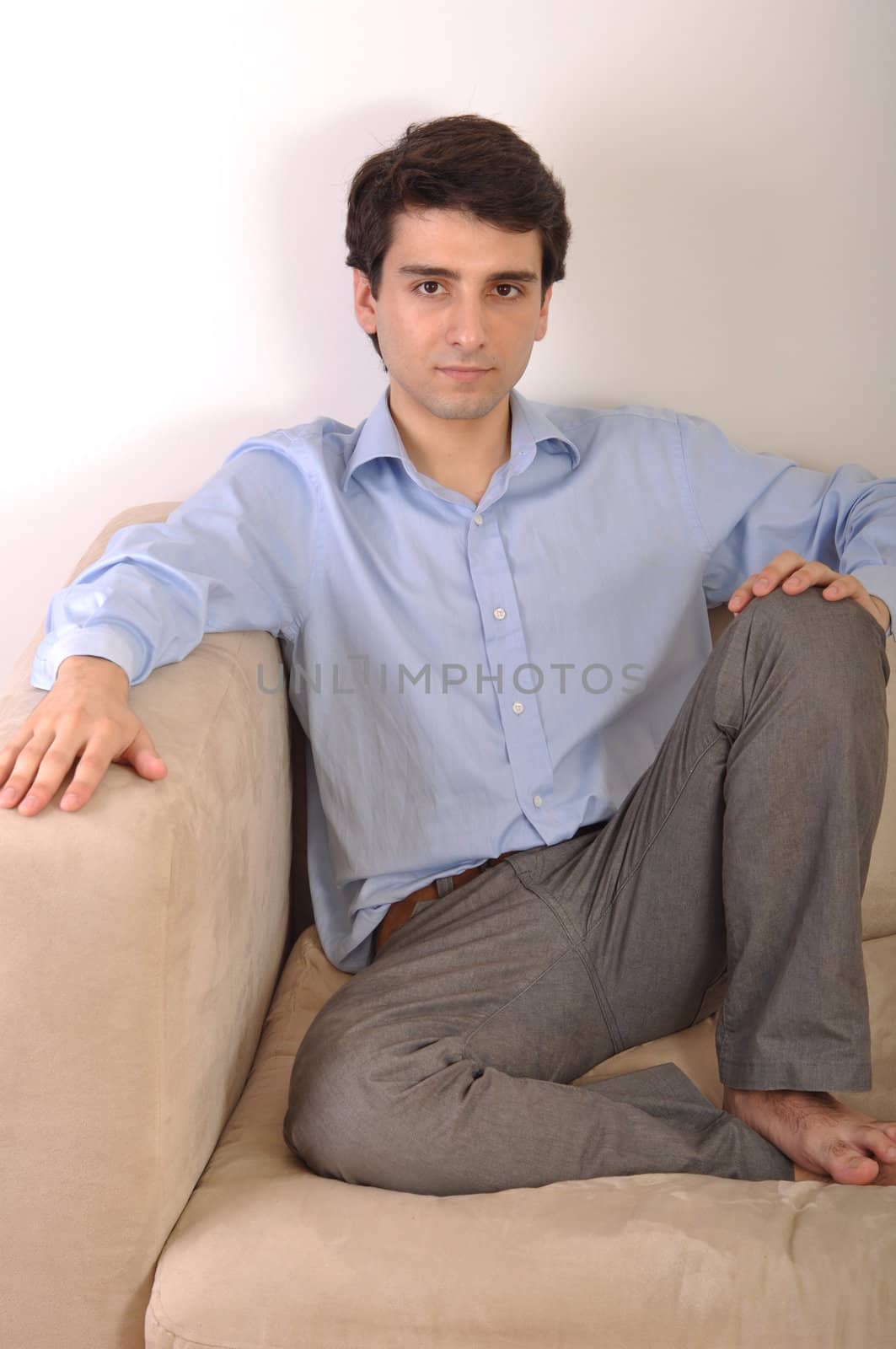 smiling attractive young man sitting on the couch