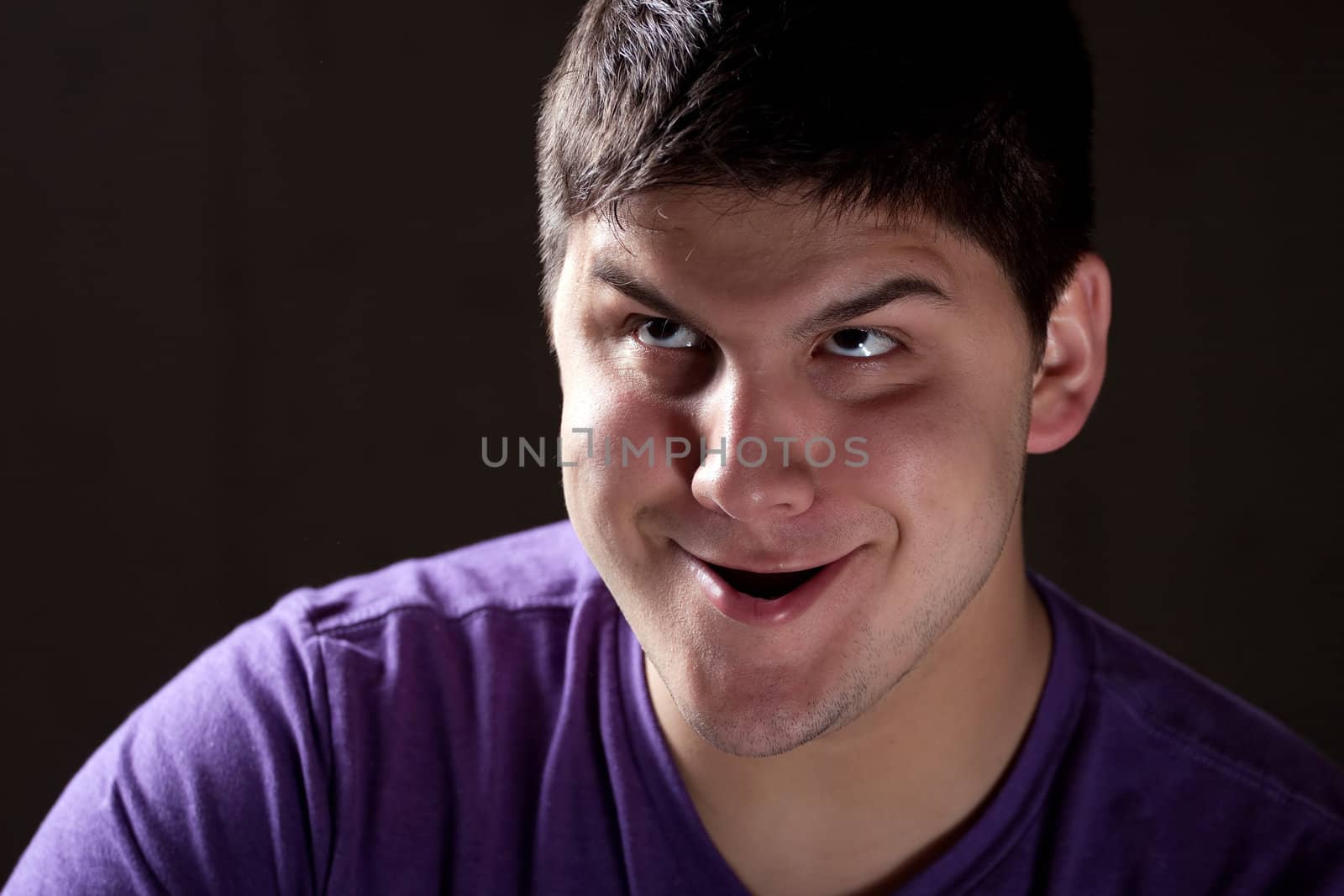A young man goofing around with a funny expression on his face.