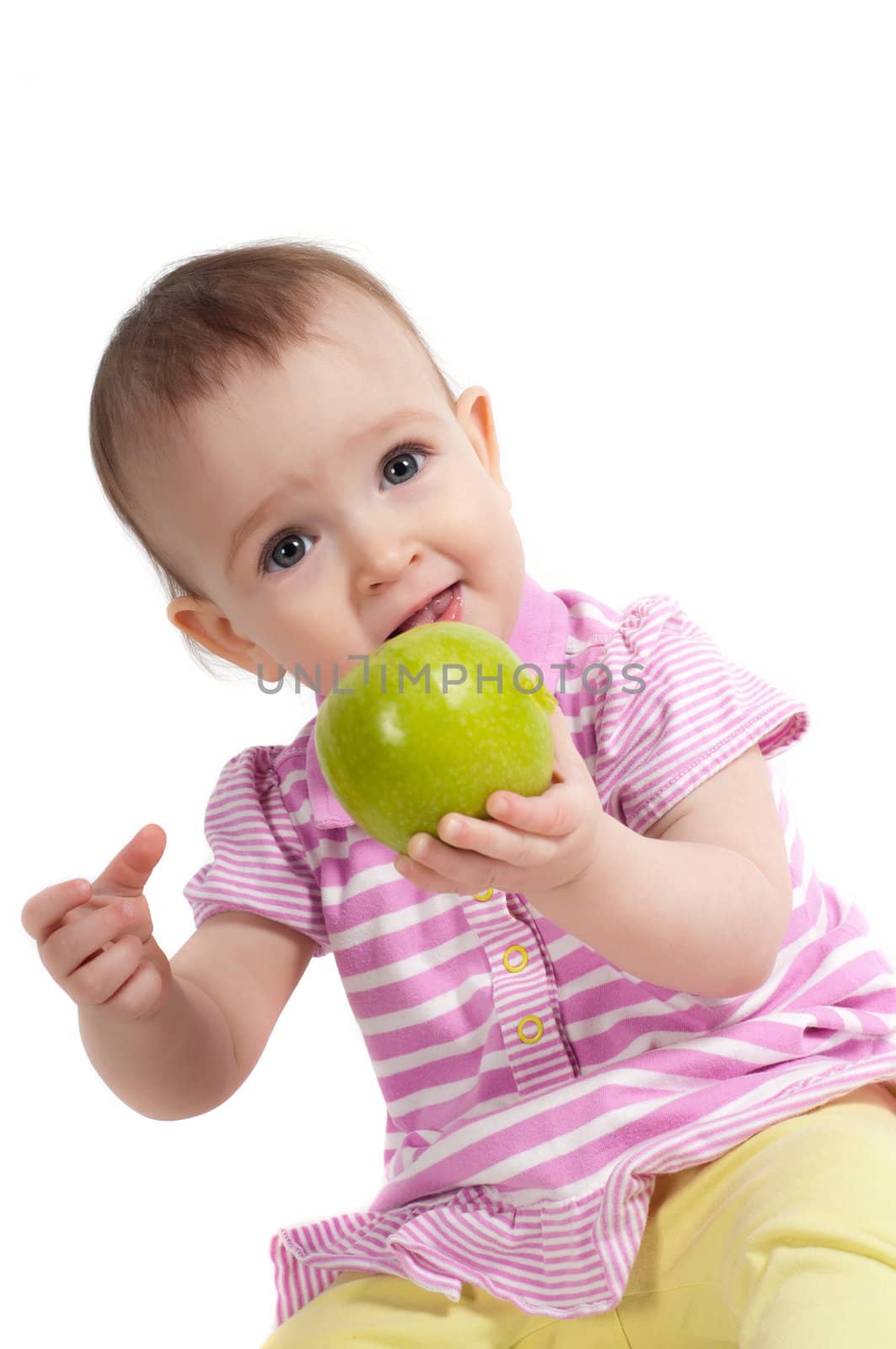 Shot of baby girl on pink eating apple