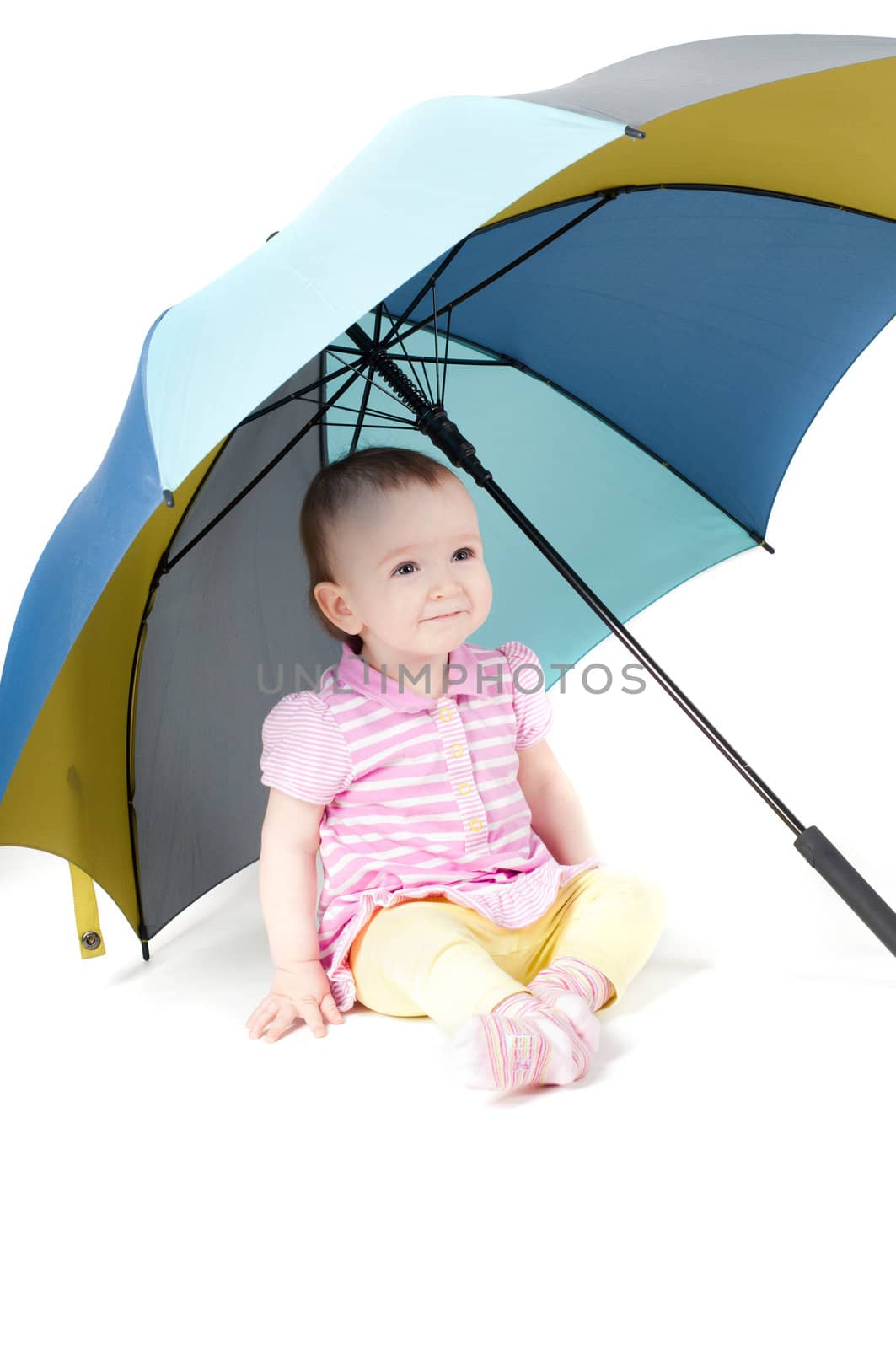 Shot of cute baby girl sitting uner umbrella