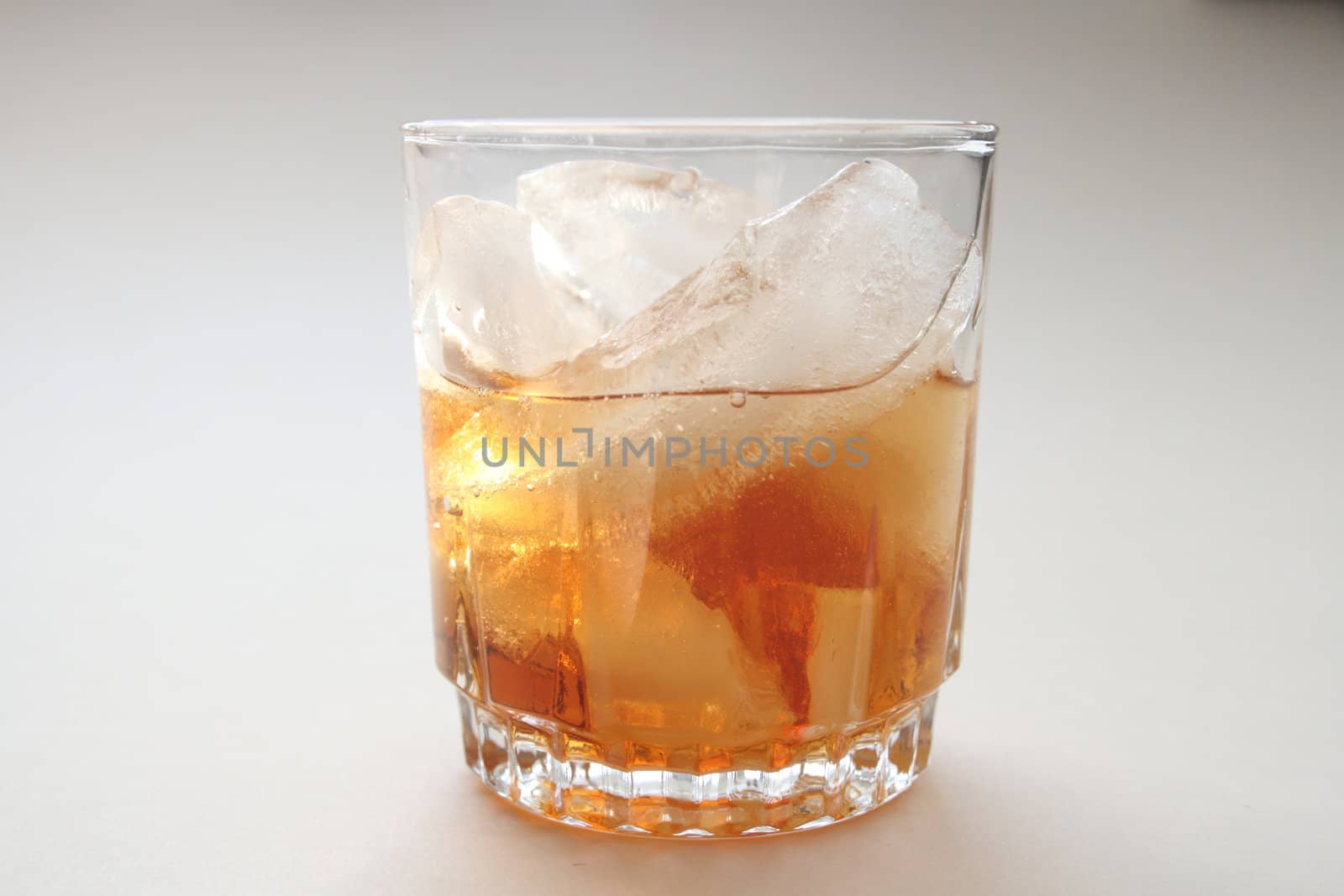 glass of rum alcohol with ice cubes by njene