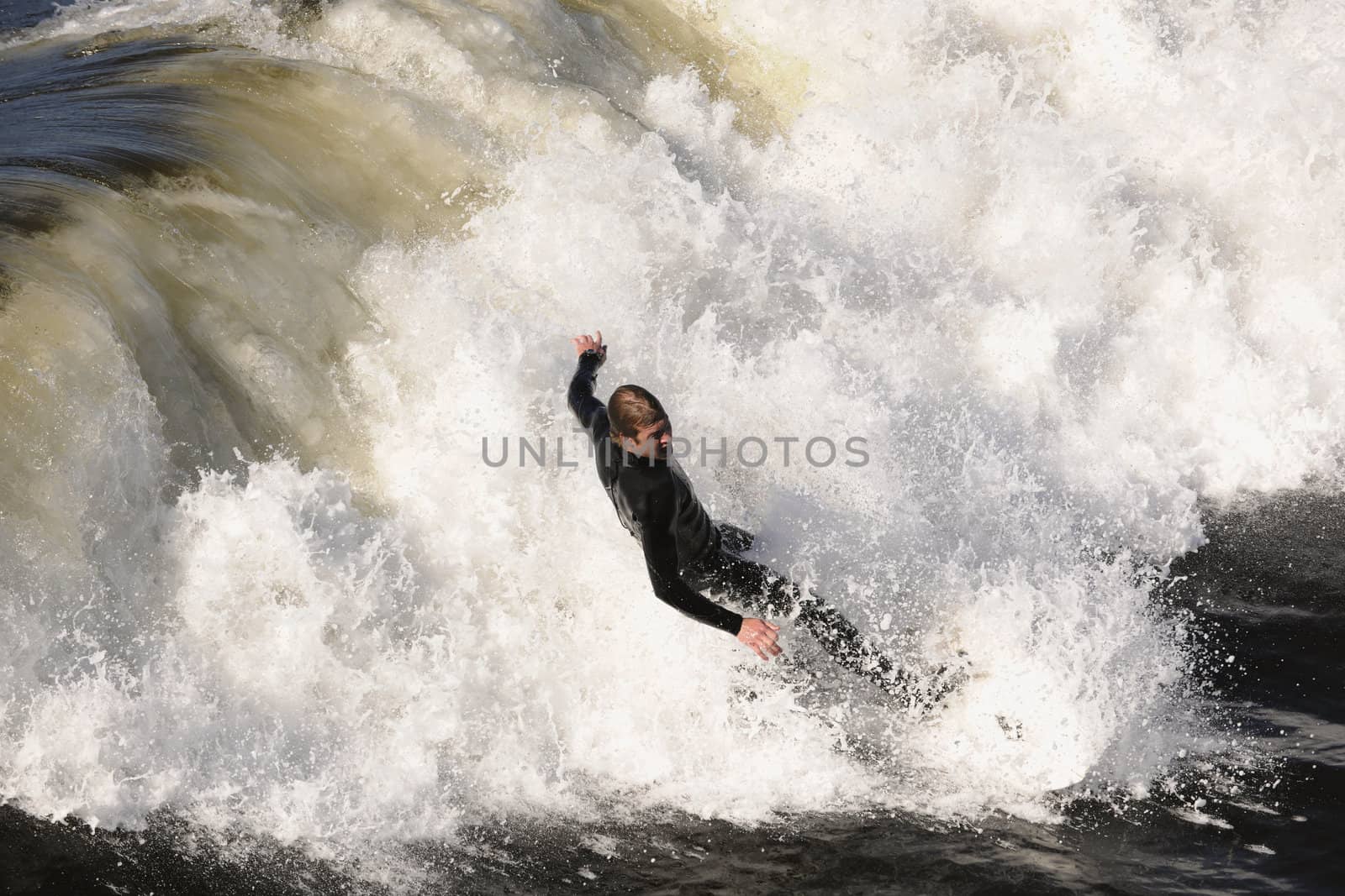 Surfer gets up on a wave. The wave twists with foam and splashes.