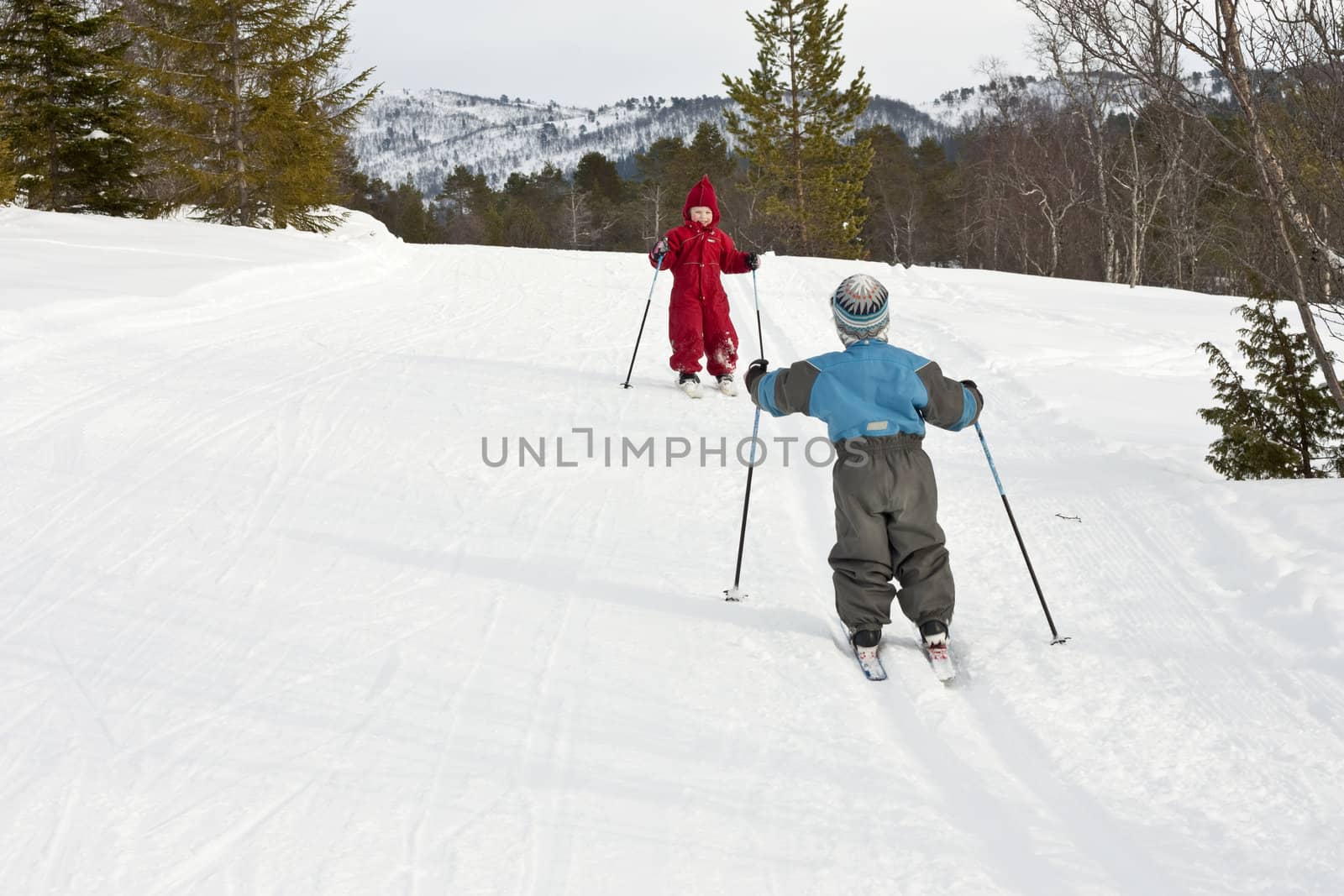 Happy small children meeting in the ski tracks