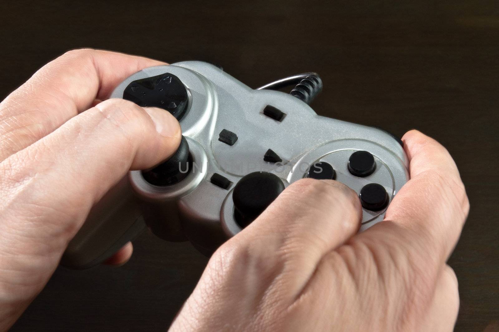 hands holding silver gamepad of video game